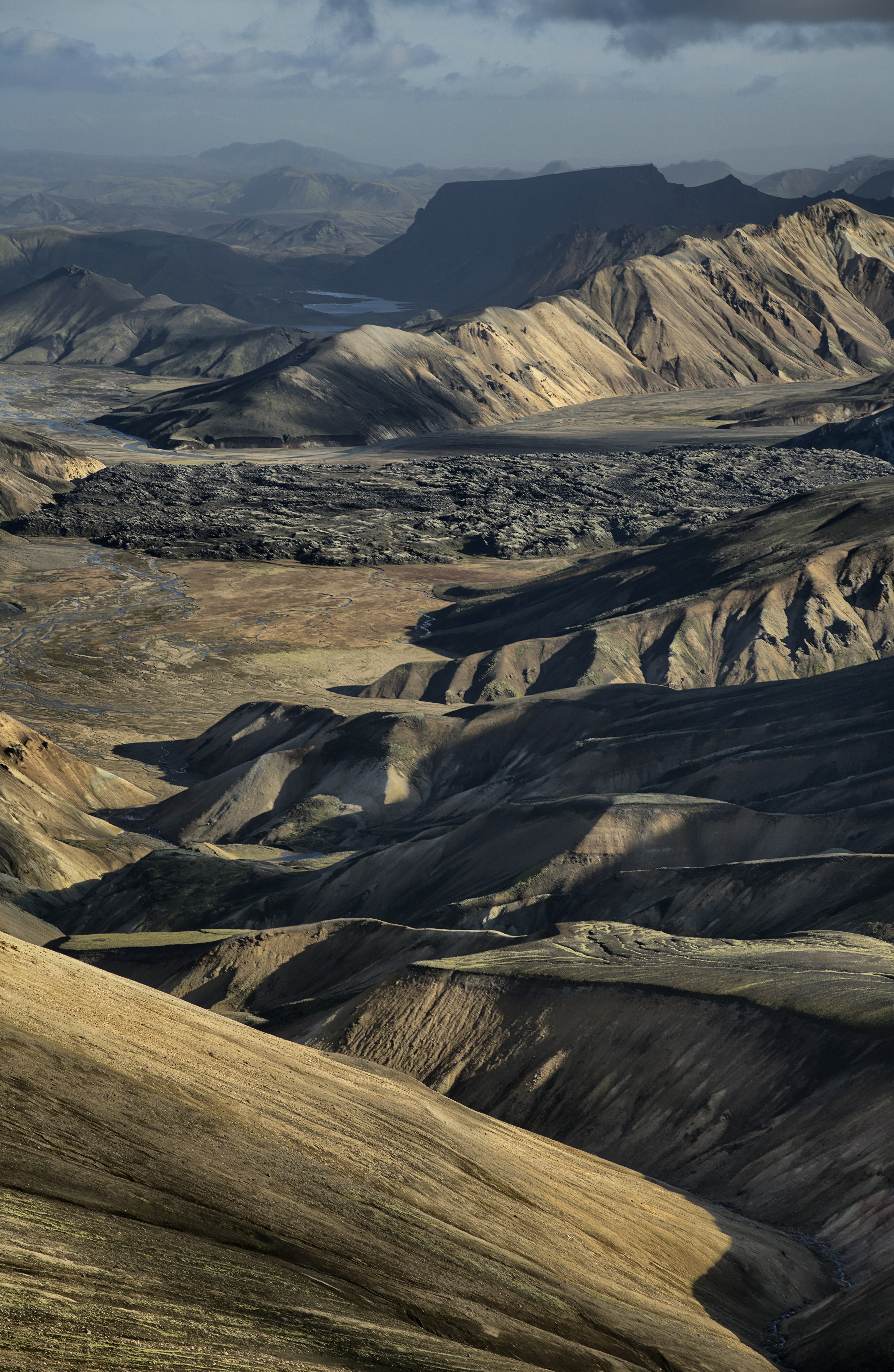 Rolling hills and rugged mountains under a blue sky