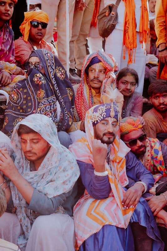 Group of men in colorful traditional attire celebrating Holi. Photo by gurpreet singh on Unsplash.