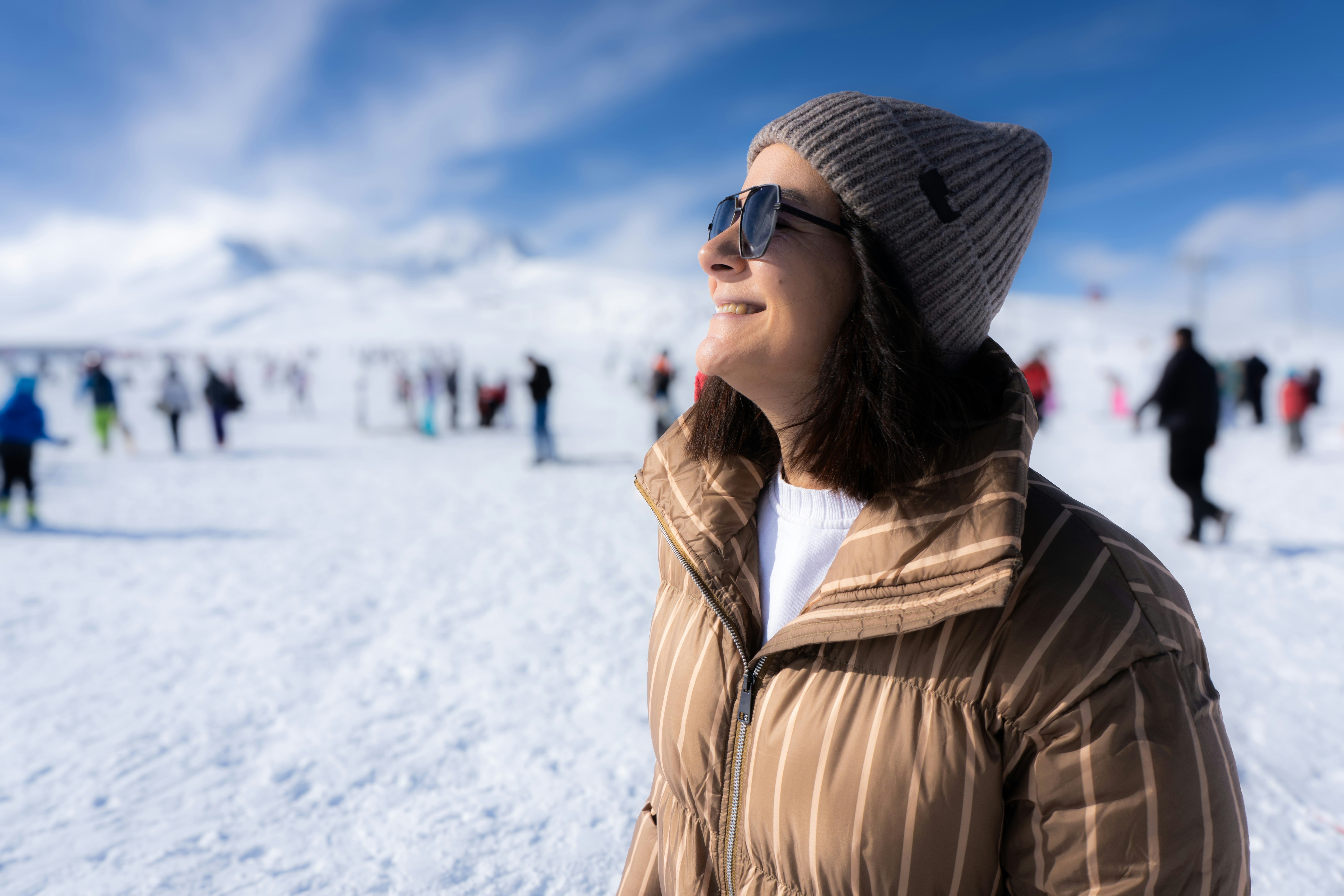 Woman in winter clothing on a snowy mountain.