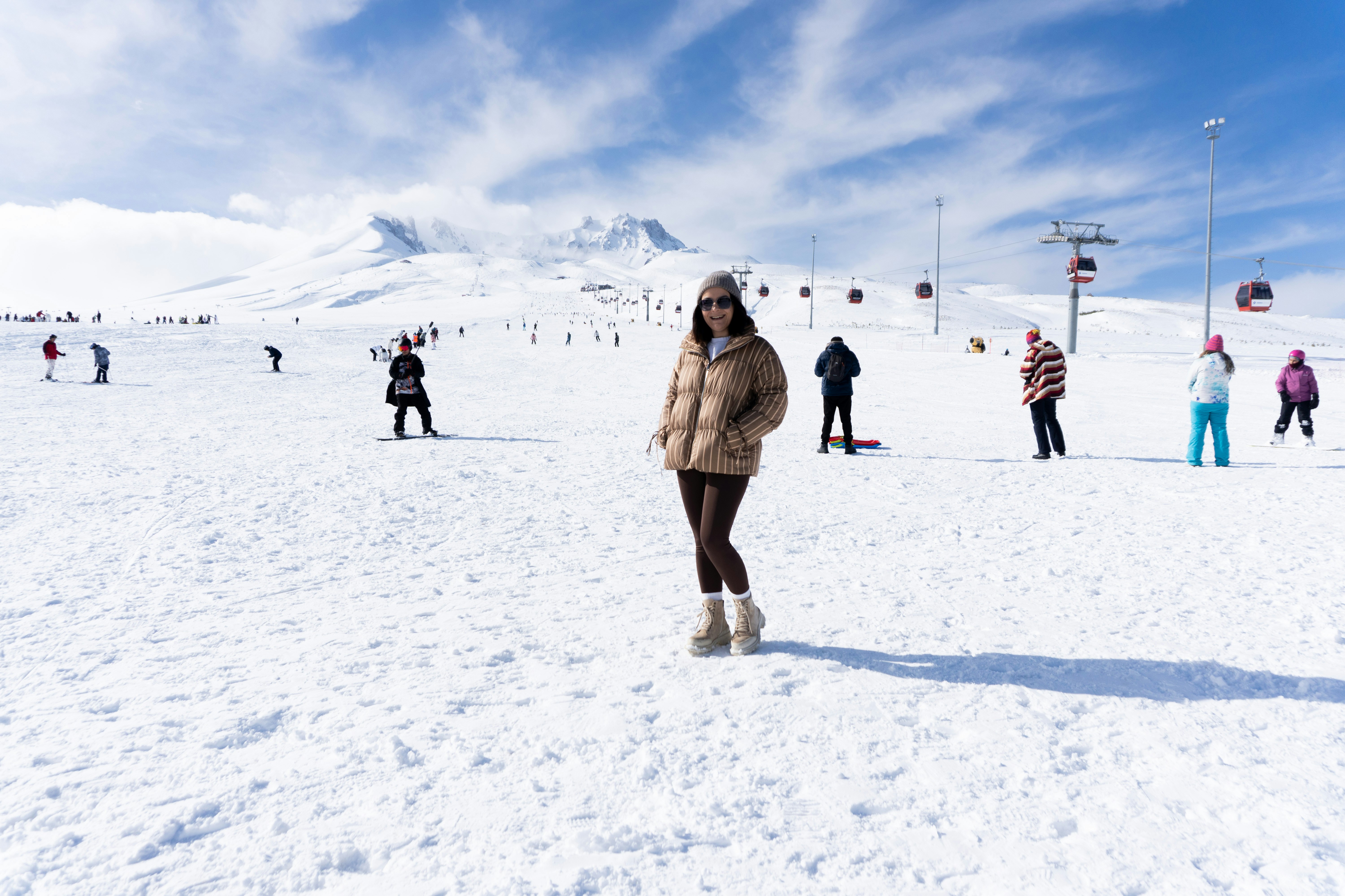 Woman standing on a snowy mountain slope with skiers
