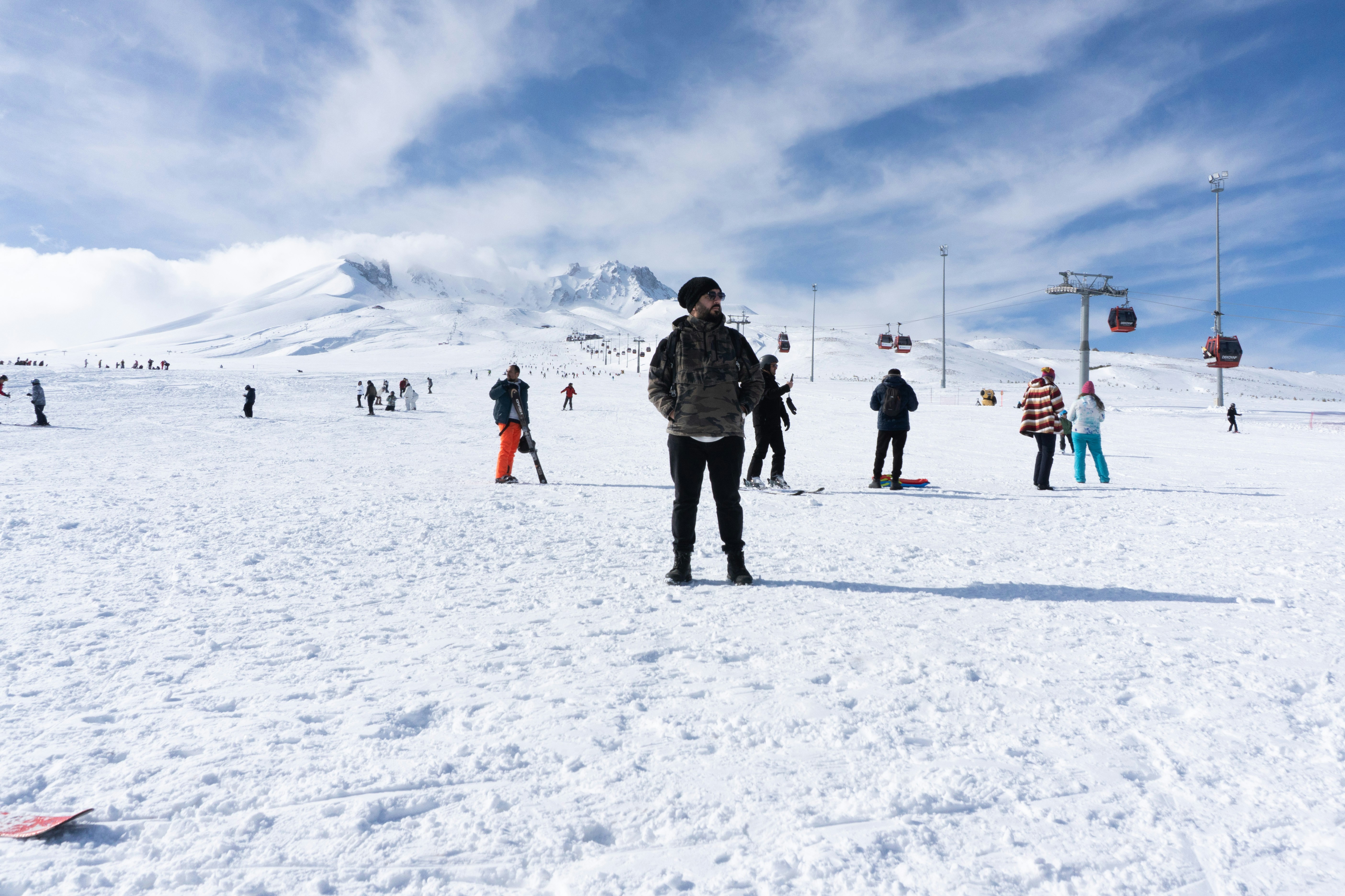 People skiing on a snowy mountain under a cloudy sky.