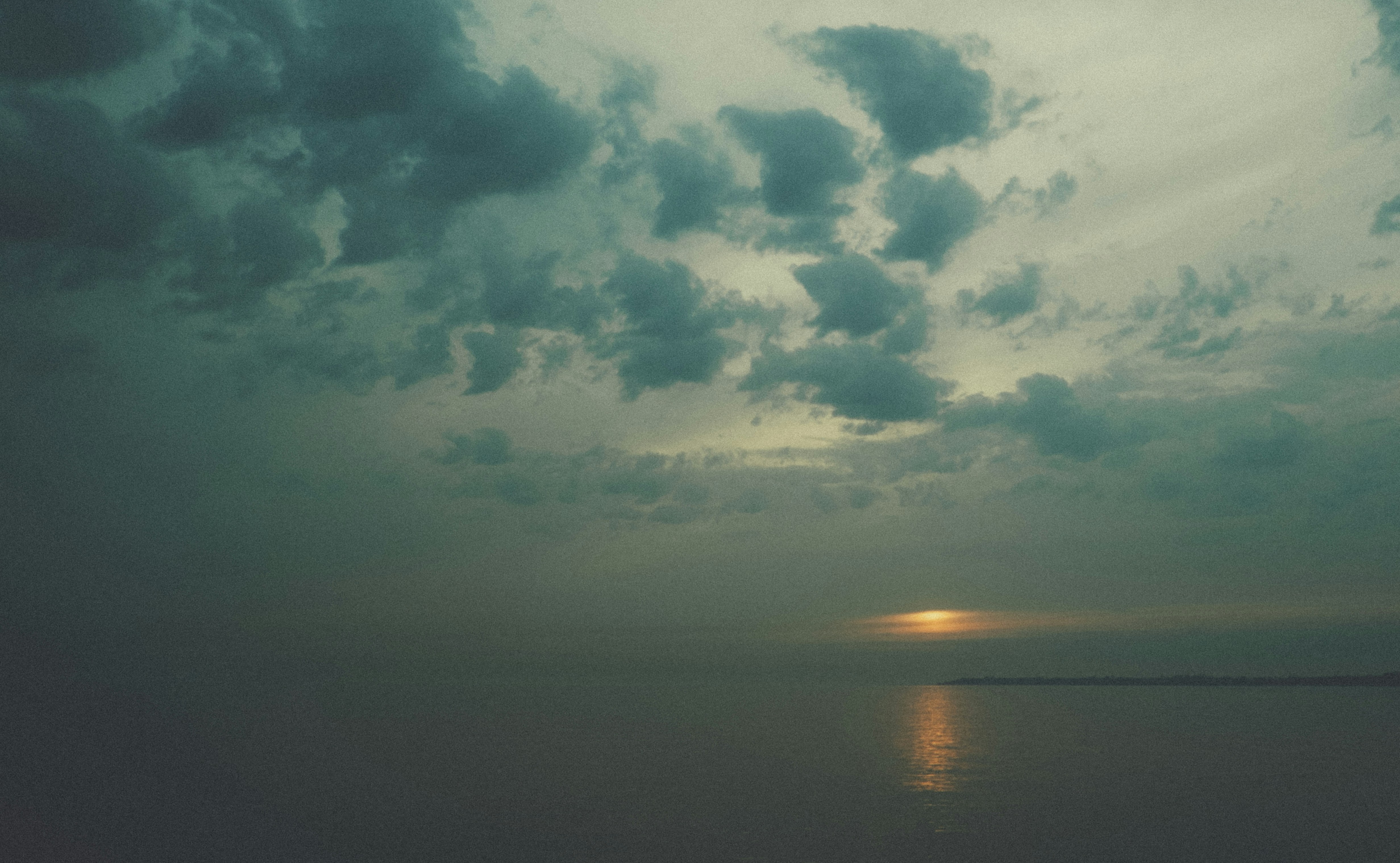 Dramatic sunset over a calm, misty ocean