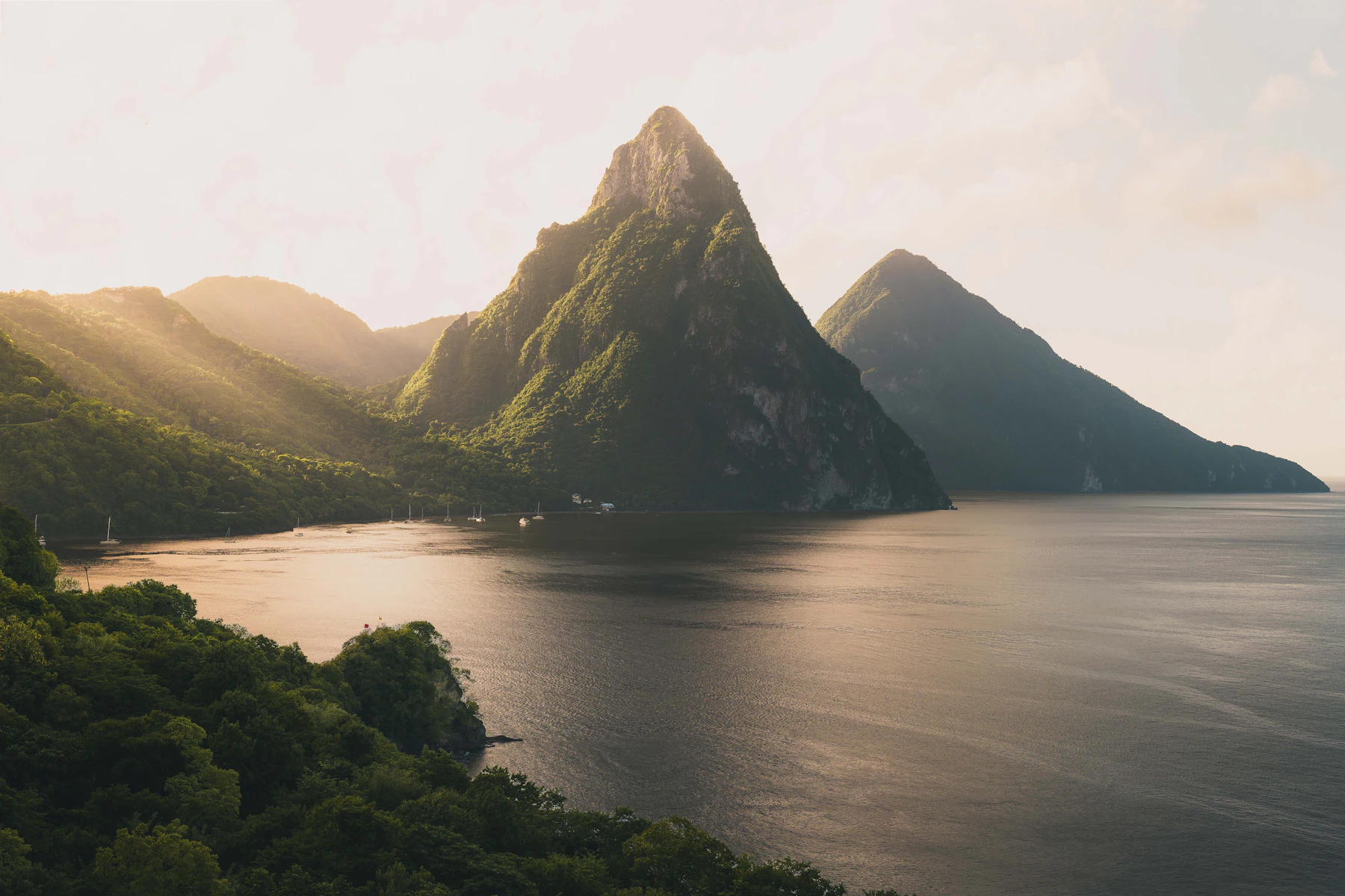 Saint Lucia's forested Pitons rising from the Caribbean Sea in warm evening light