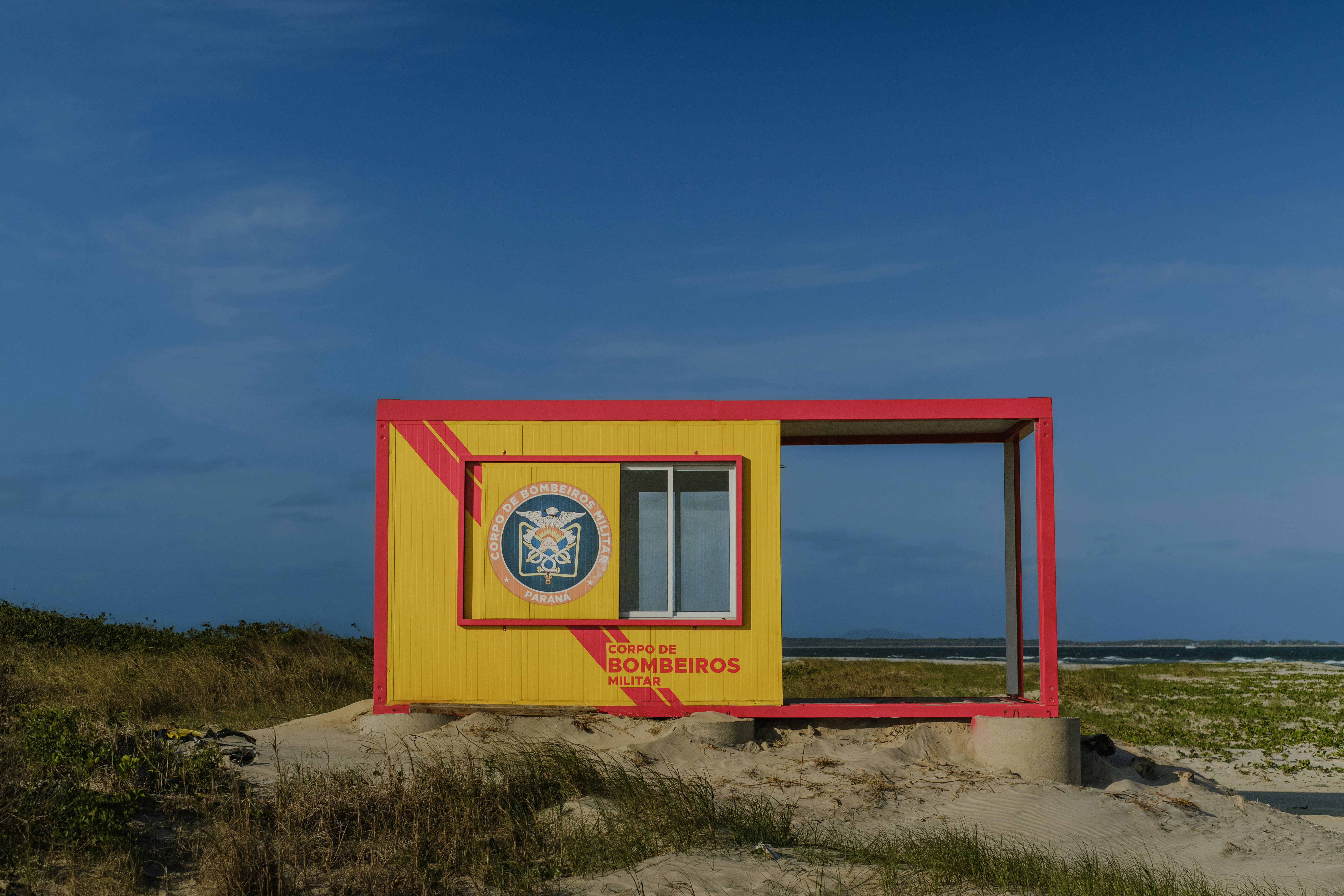 A modern beach structure with a window and open frame.