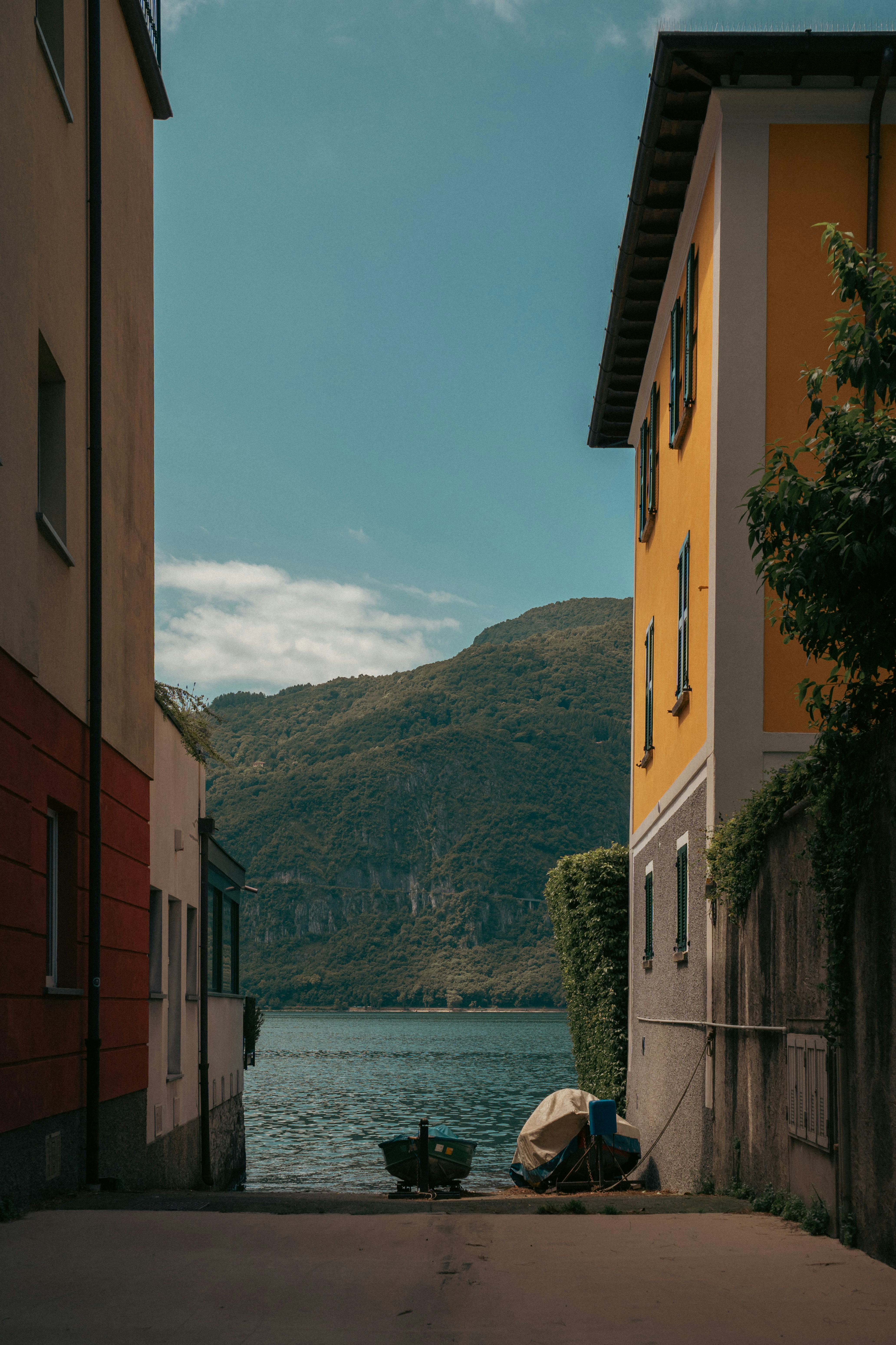 Buildings frame a tranquil lake with a distant mountain.