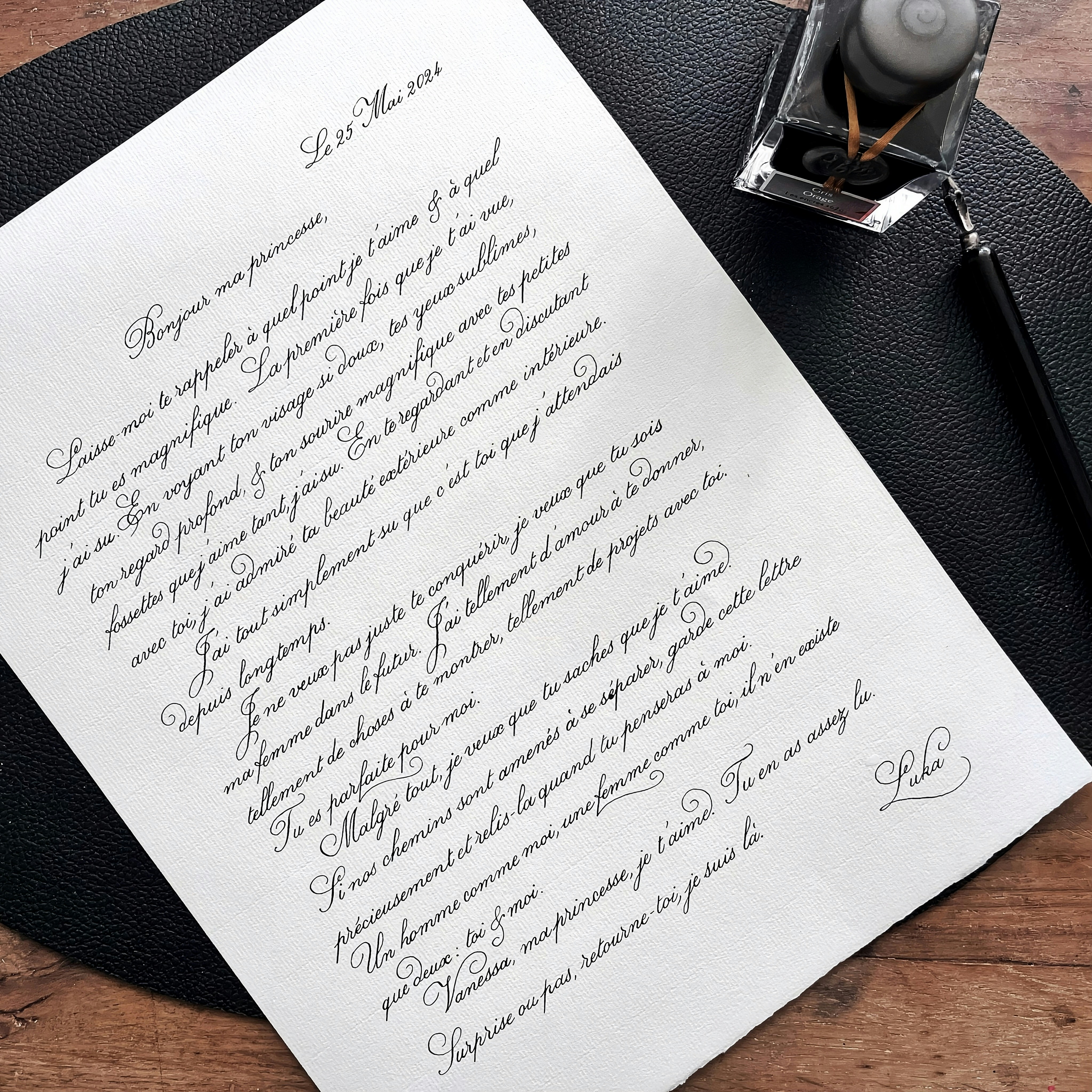 A handwritten letter with calligraphy and inkwell and quill
