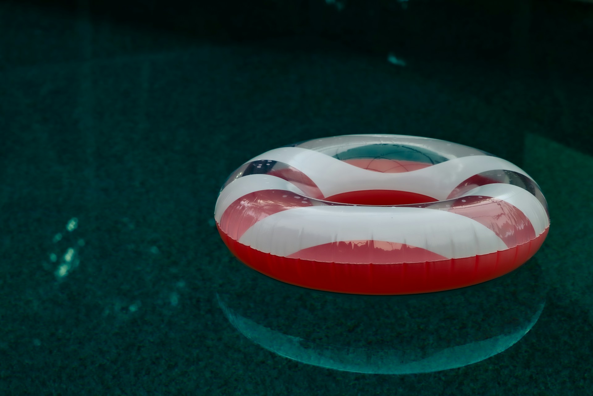 Inflatable ring with american flag pattern floats in pool.