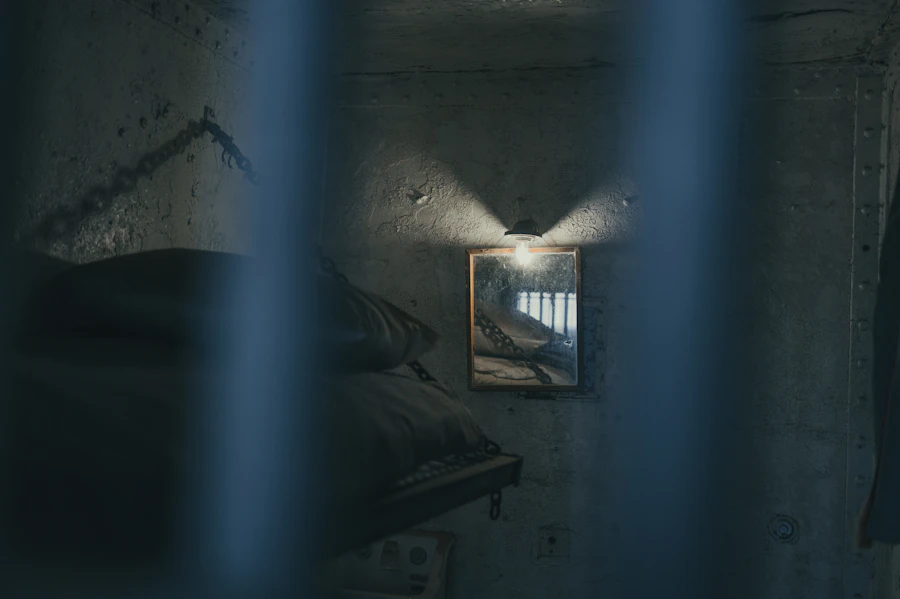 A dimly lit prison cell with a bed and barred window