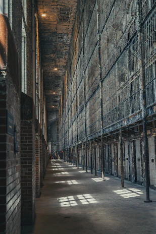A long, dim hallway in an abandoned prison