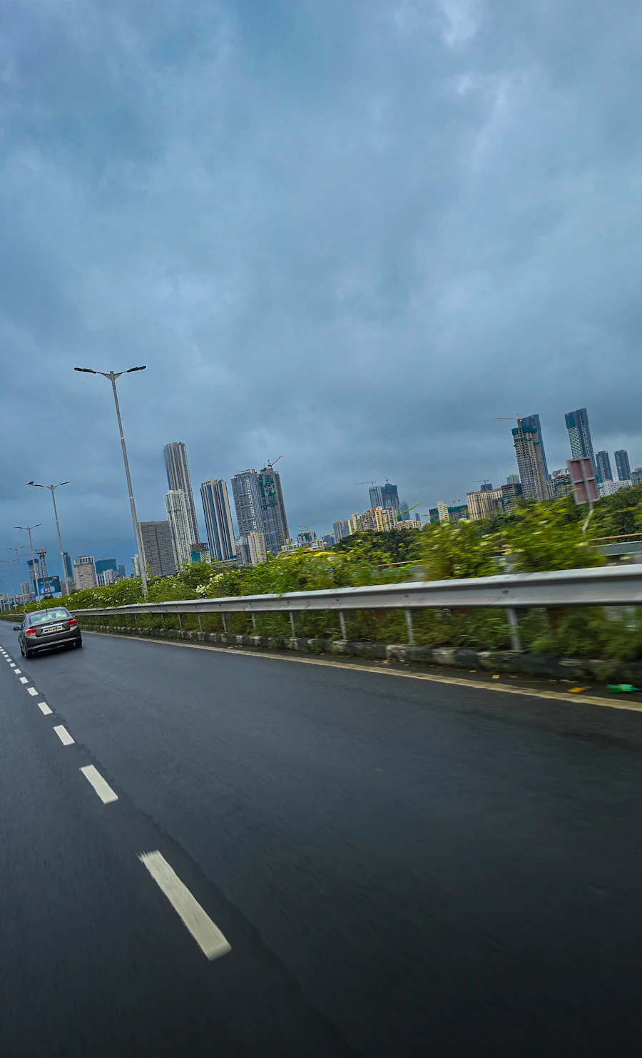 SUV on a wet road with city skyline