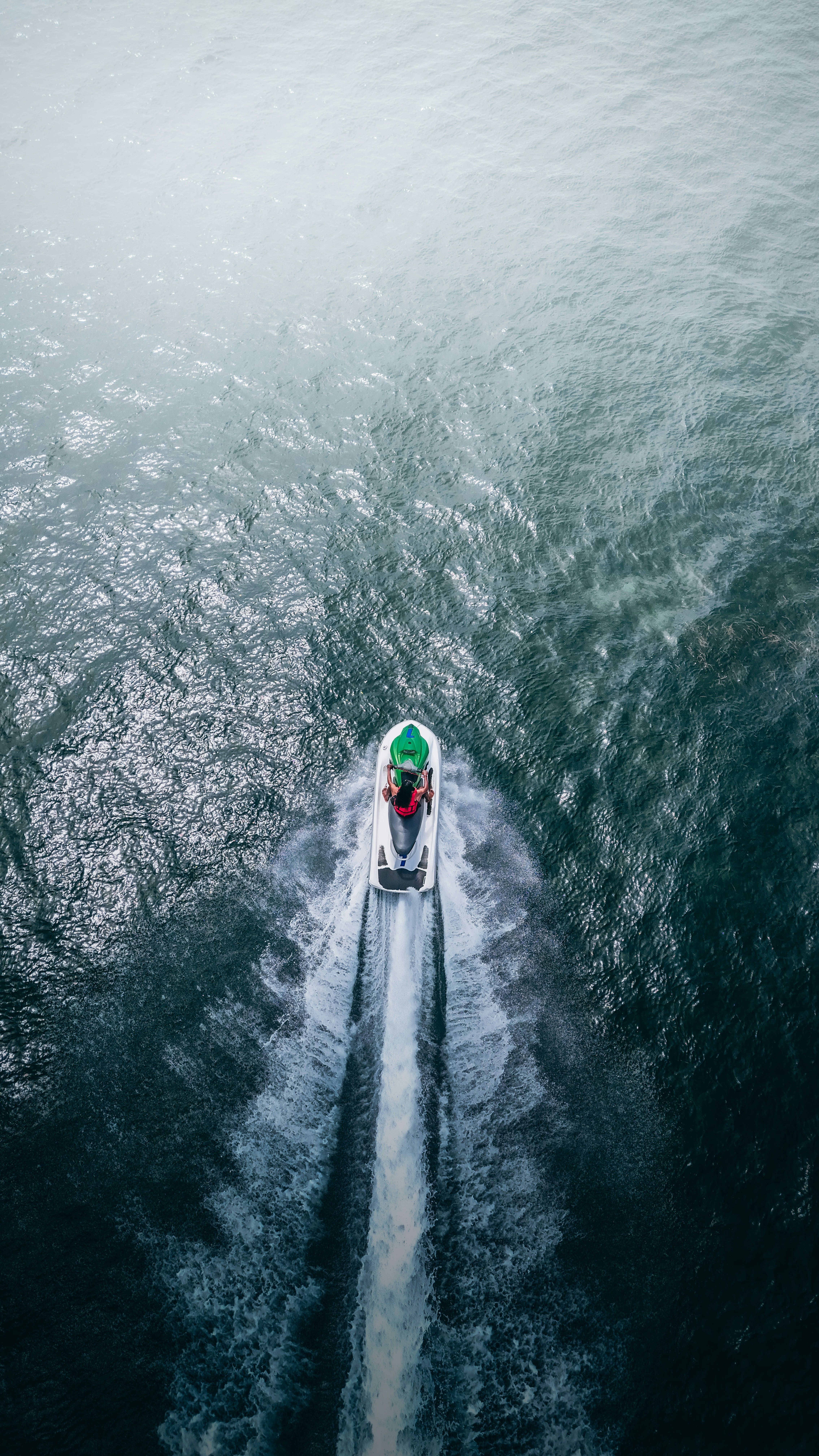 Jet ski speeding through the ocean leaving a white wake.