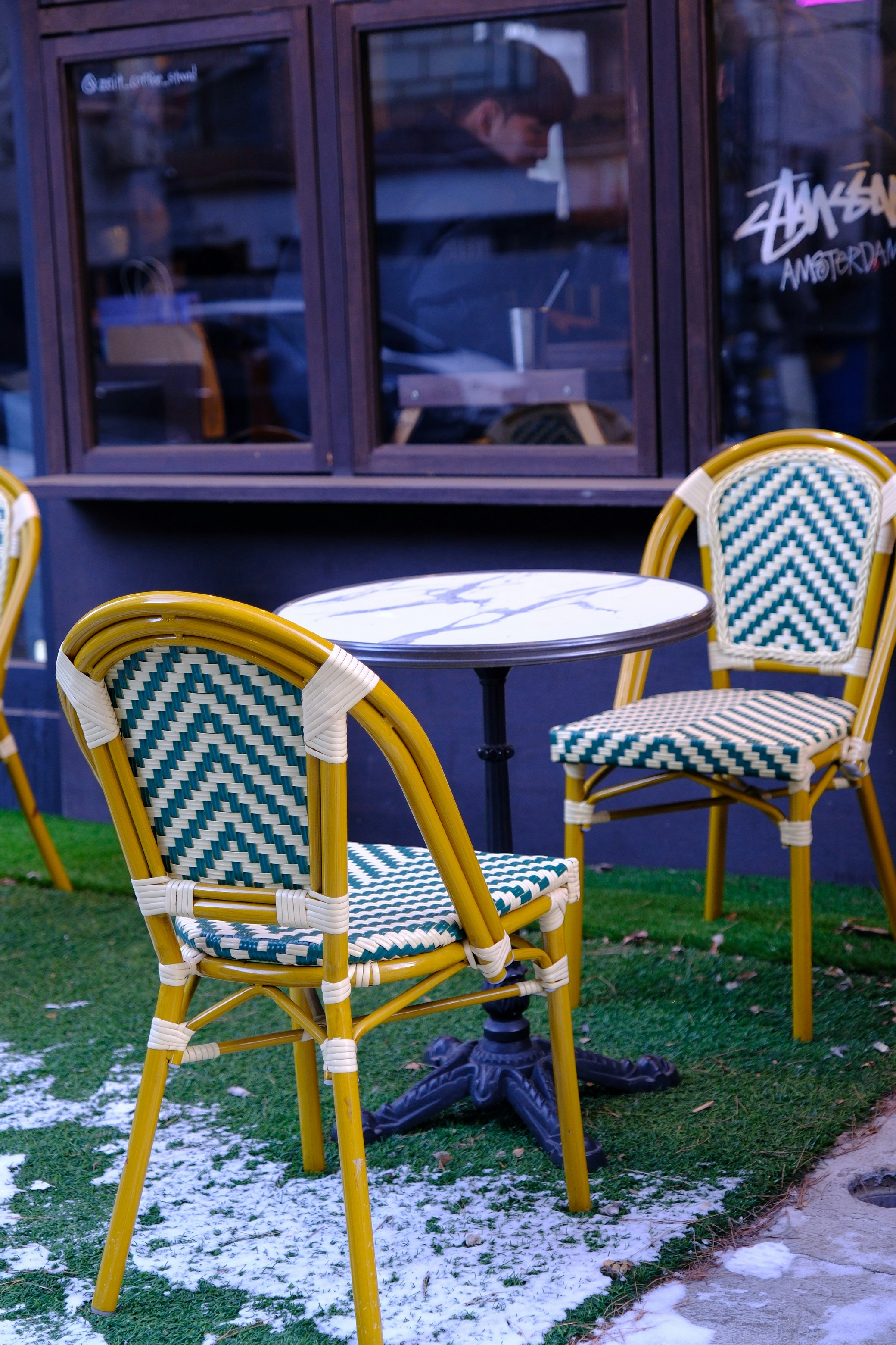 Outdoor cafe tables and chairs on artificial grass