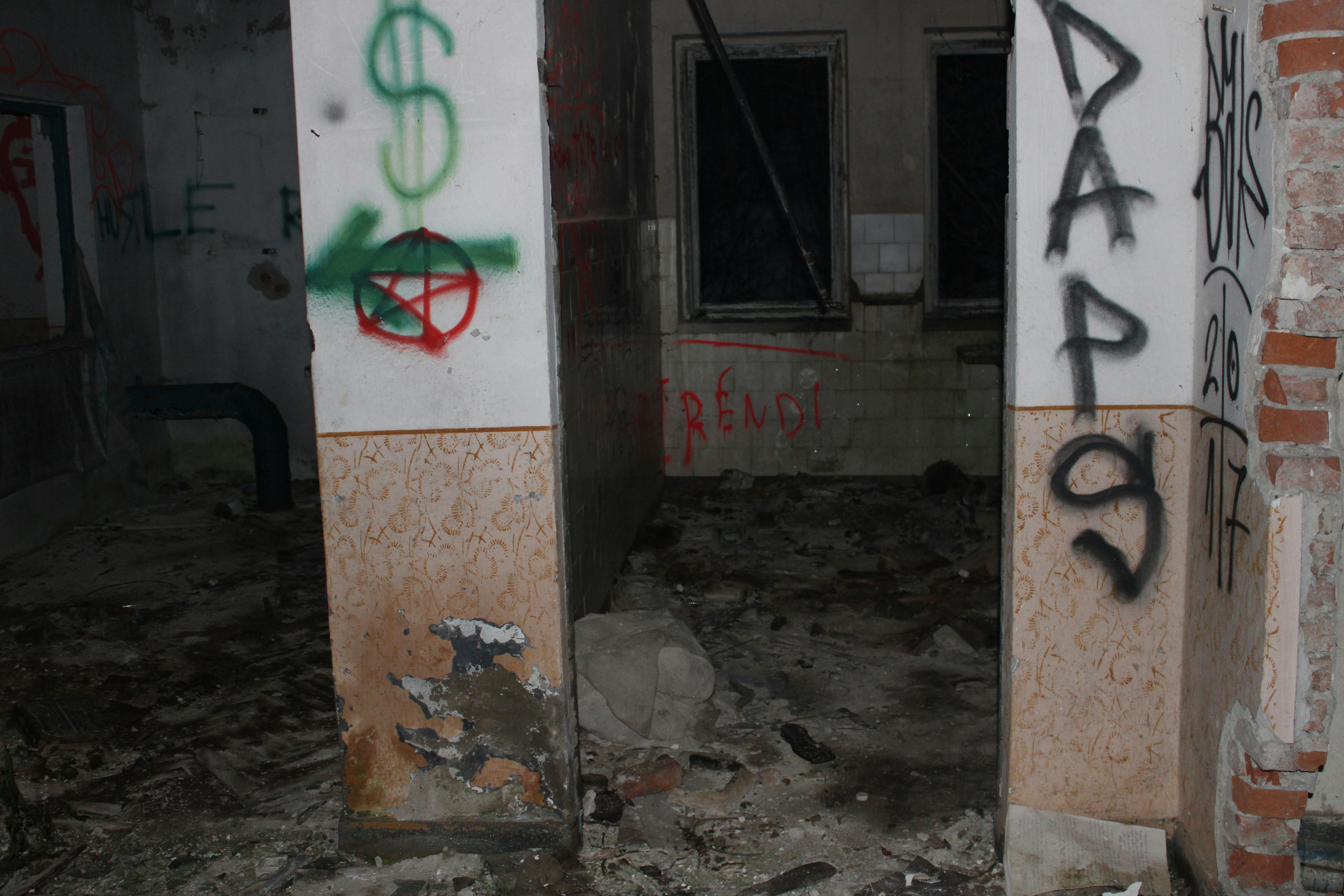Graffiti on abandoned building pillars with debris