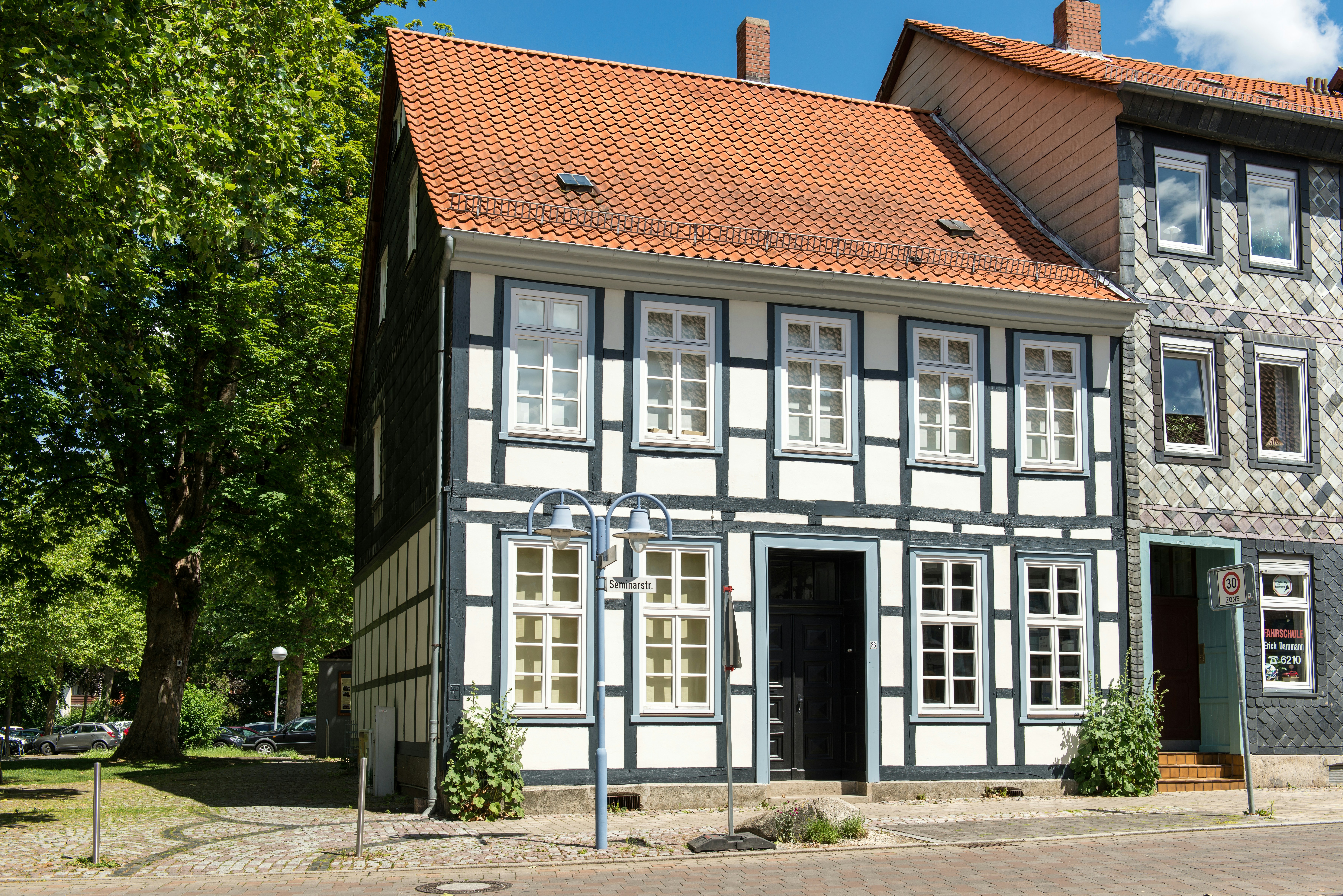 A historic half-timbered house with a red roof.