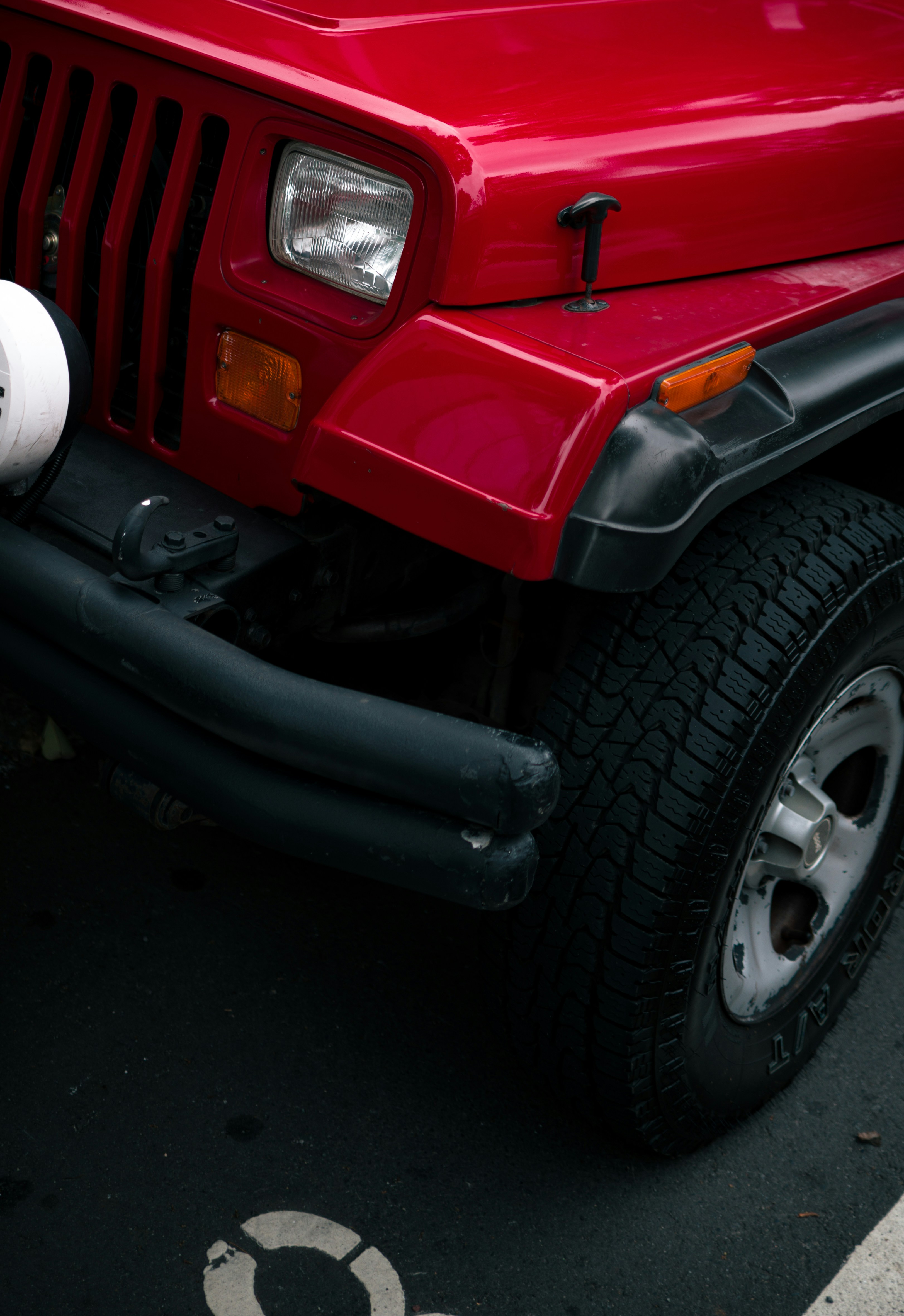 Rotes Jeep-Wrangler-Frontdetail mit Reifen.