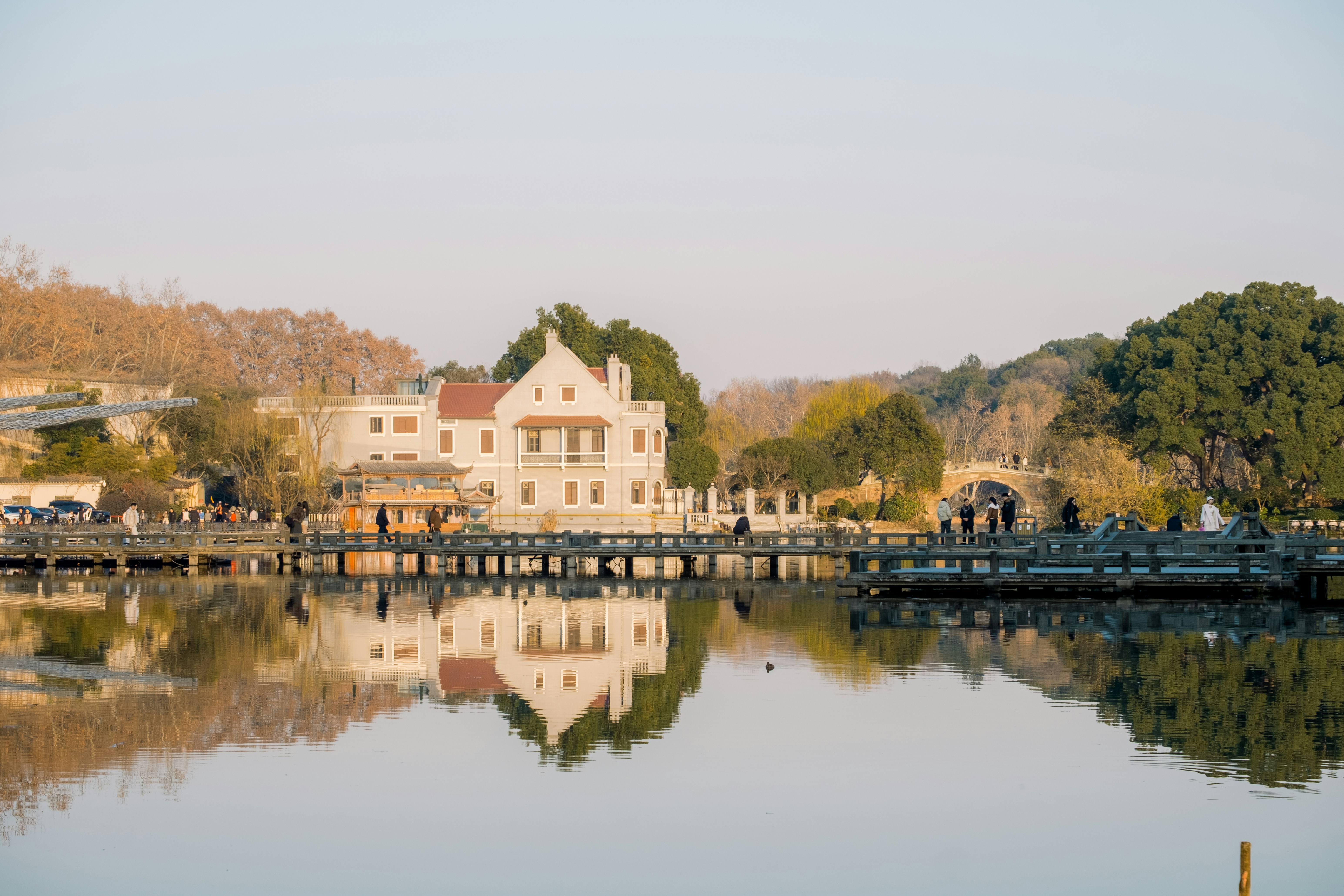 White building reflected in calm water with trees