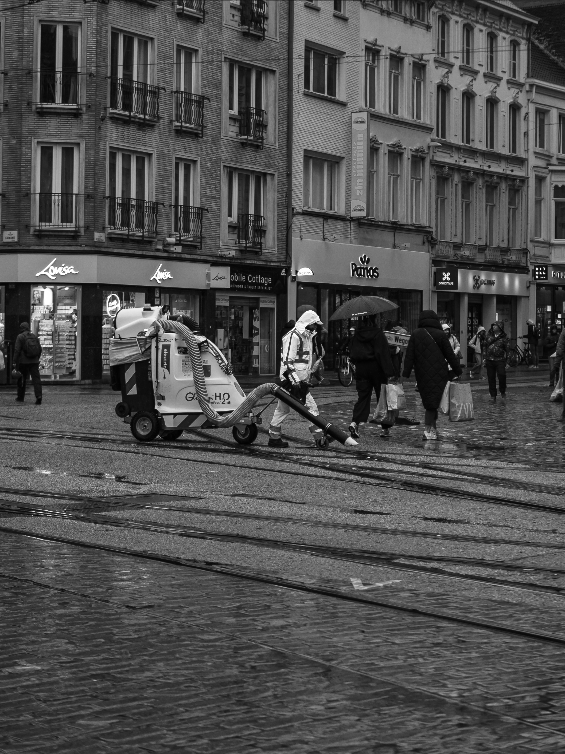 Street cleaner with vacuum machine on wet city street