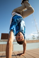 Man performing a handstand outdoors on a sunny day.