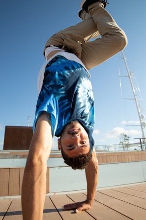 Man performing a handstand outdoors on a sunny day.