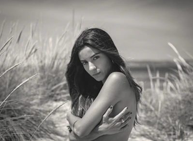 Woman posing on a beach with tall grass