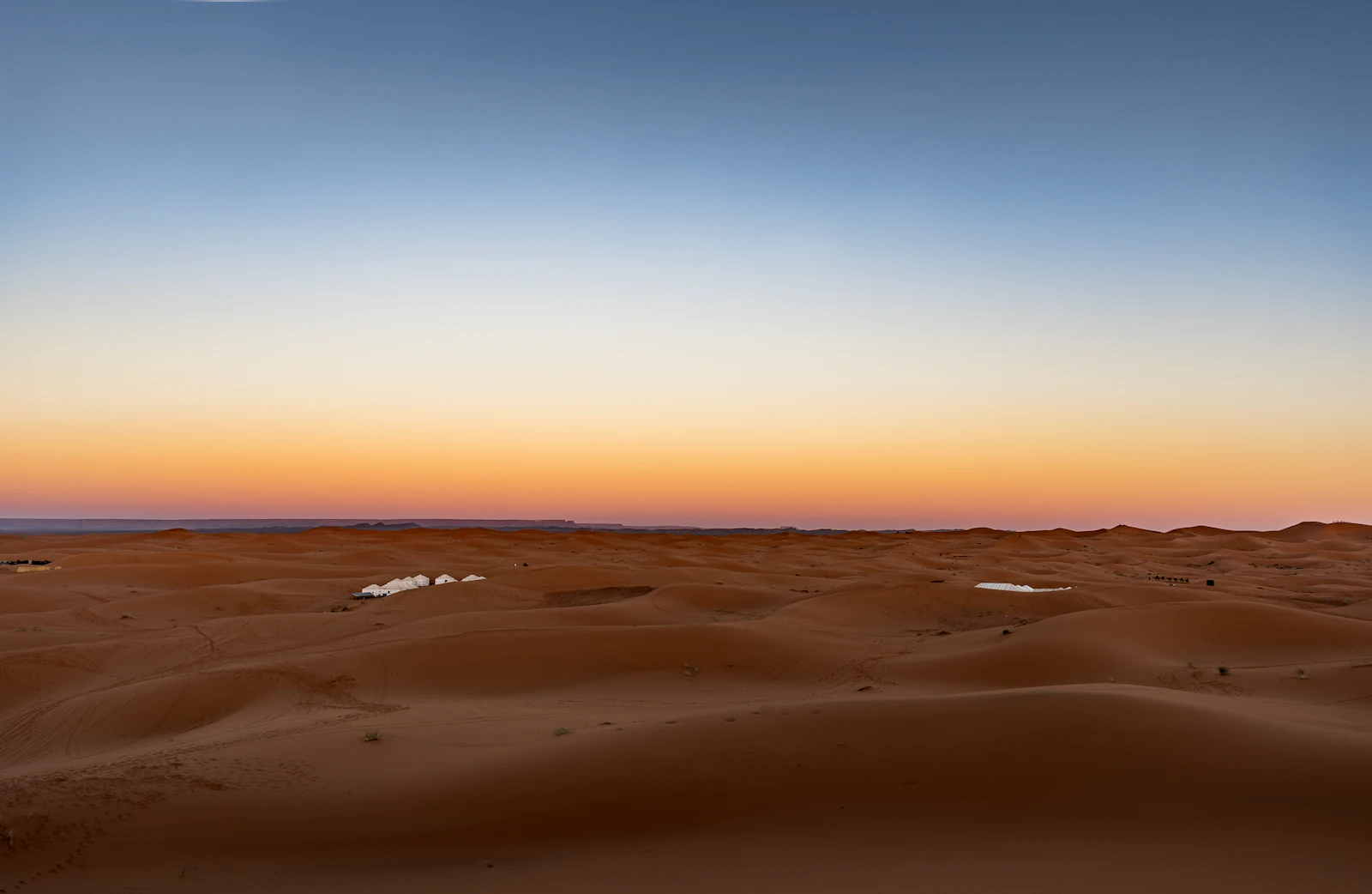 Sahara sand dunes under a glowing sunset sky