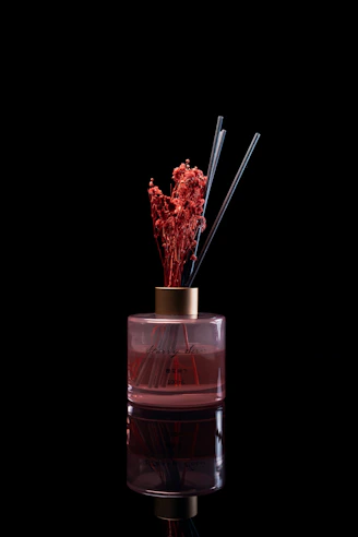 Reed diffuser with dried flowers on black background