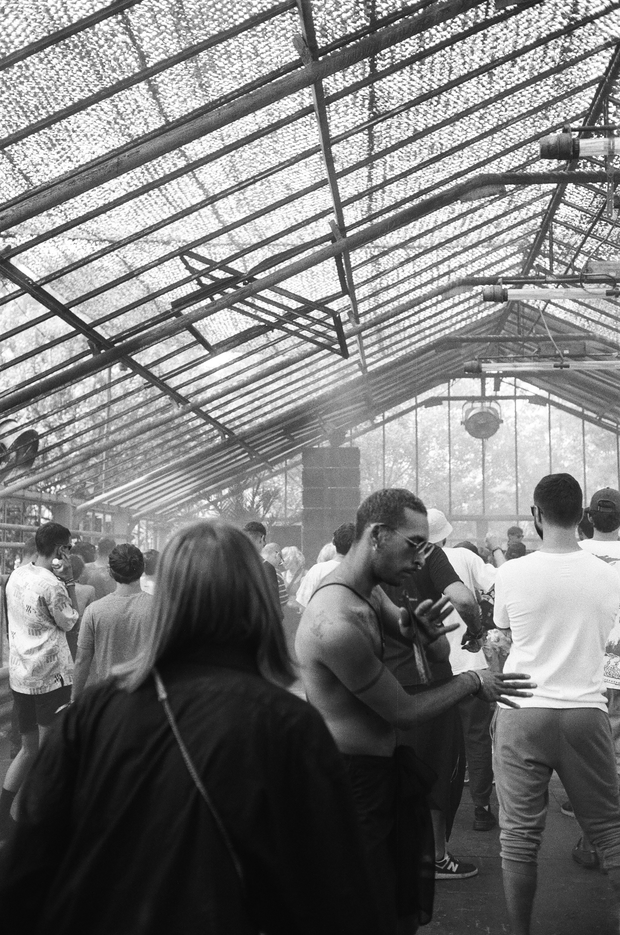 Persone che ballano in un magazzino affollato con un tetto traslucido.