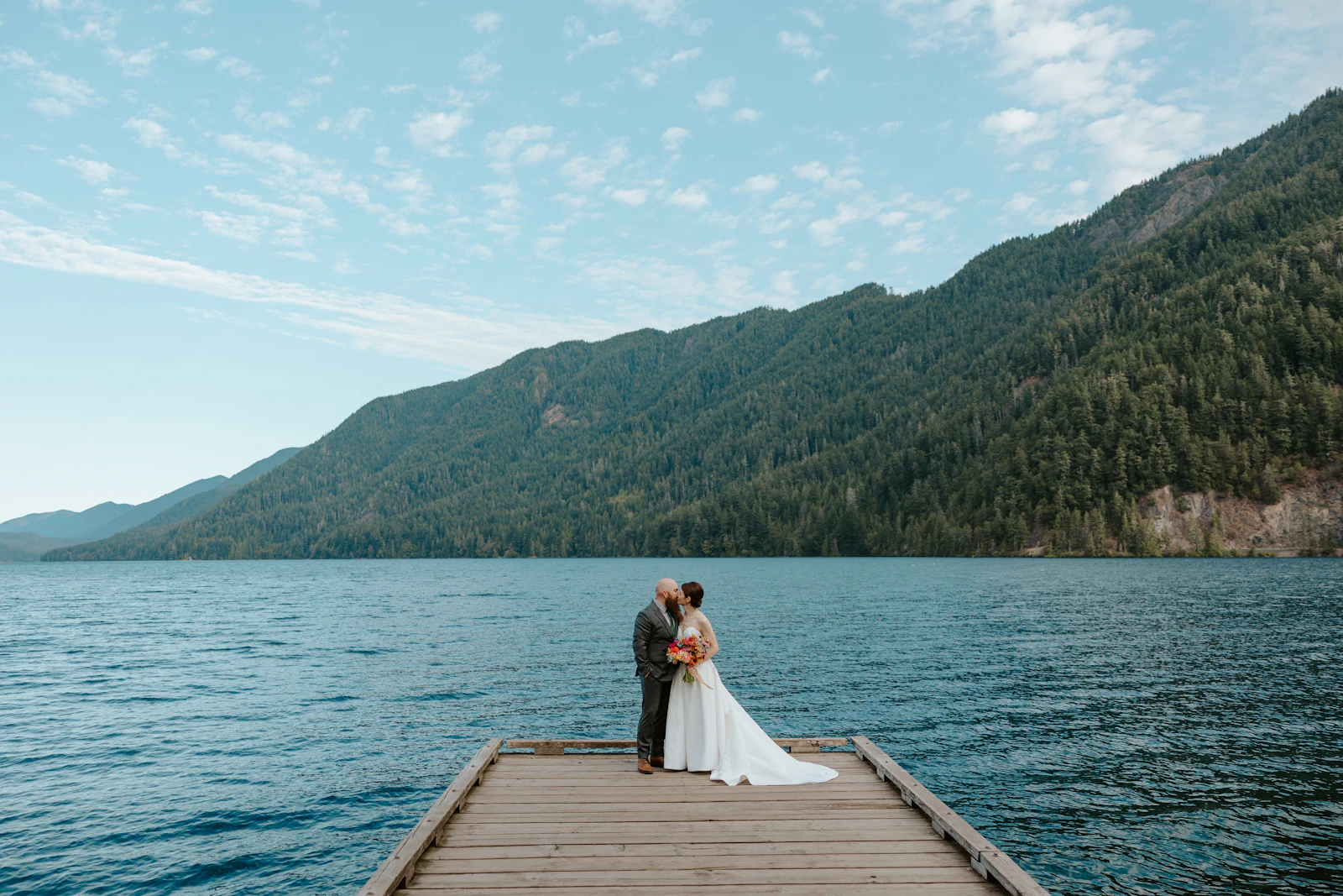 Couple on a dock by a mountain lake