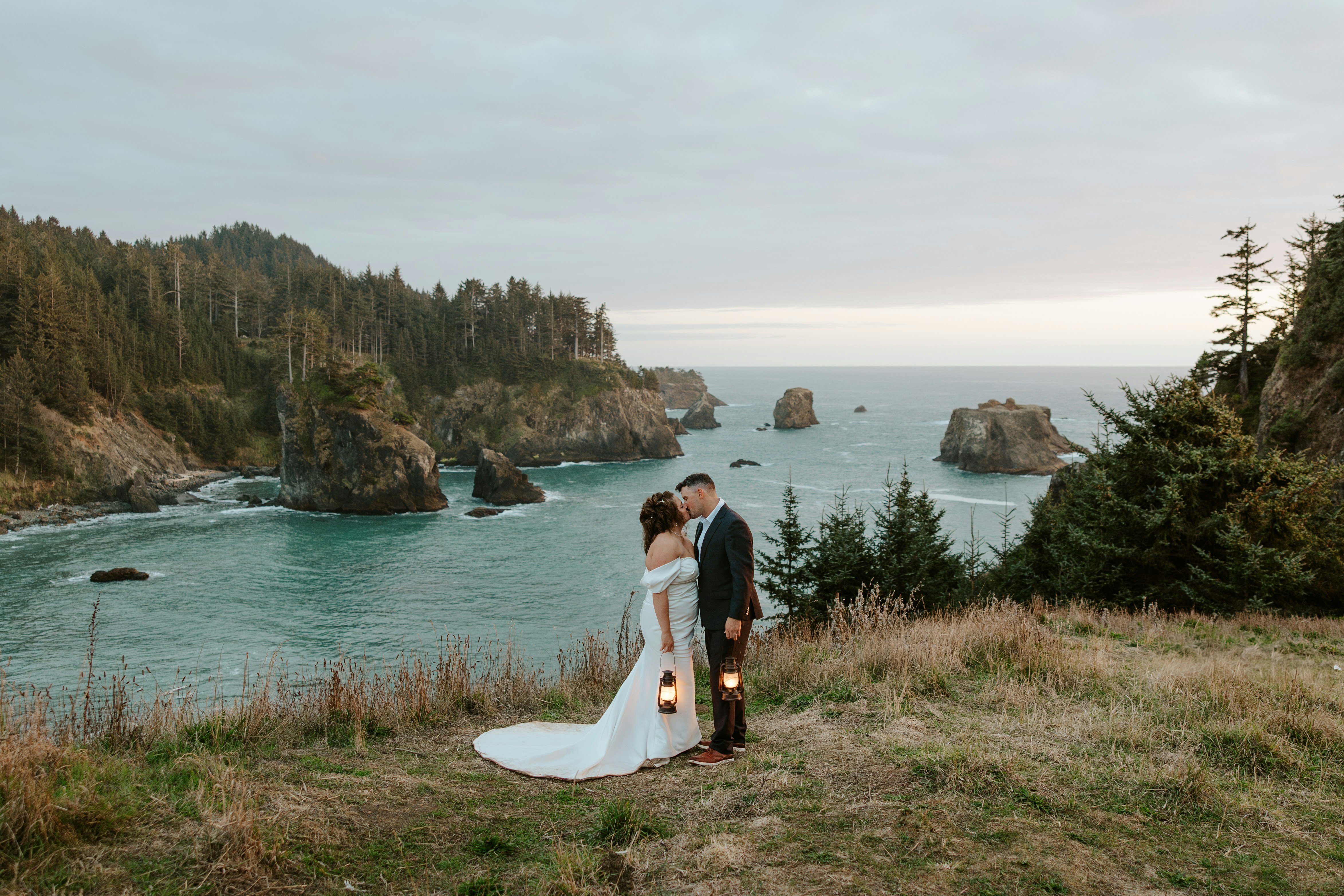A couple in wedding attire by the ocean