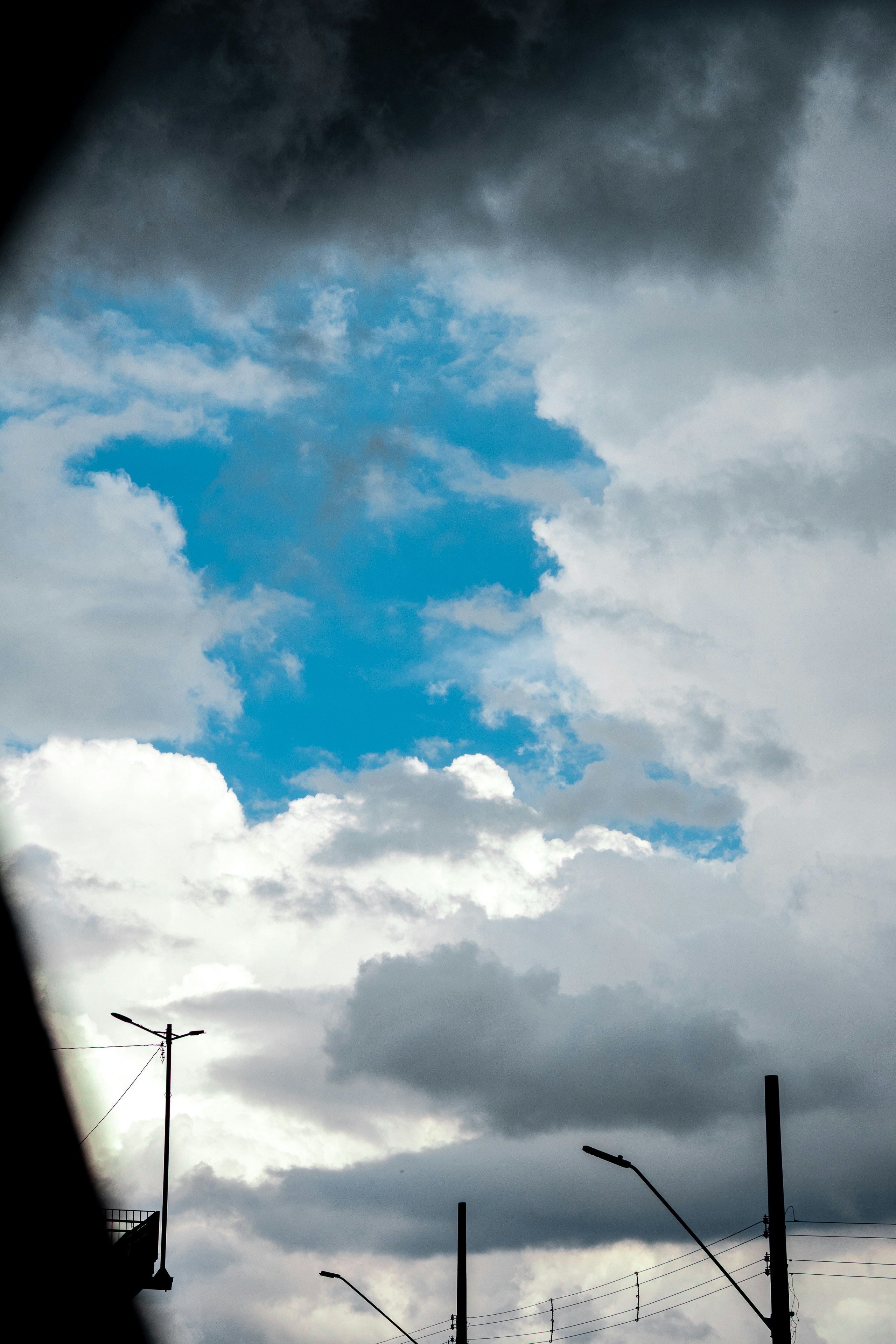 Bright blue sky peeking through dramatic grey clouds
