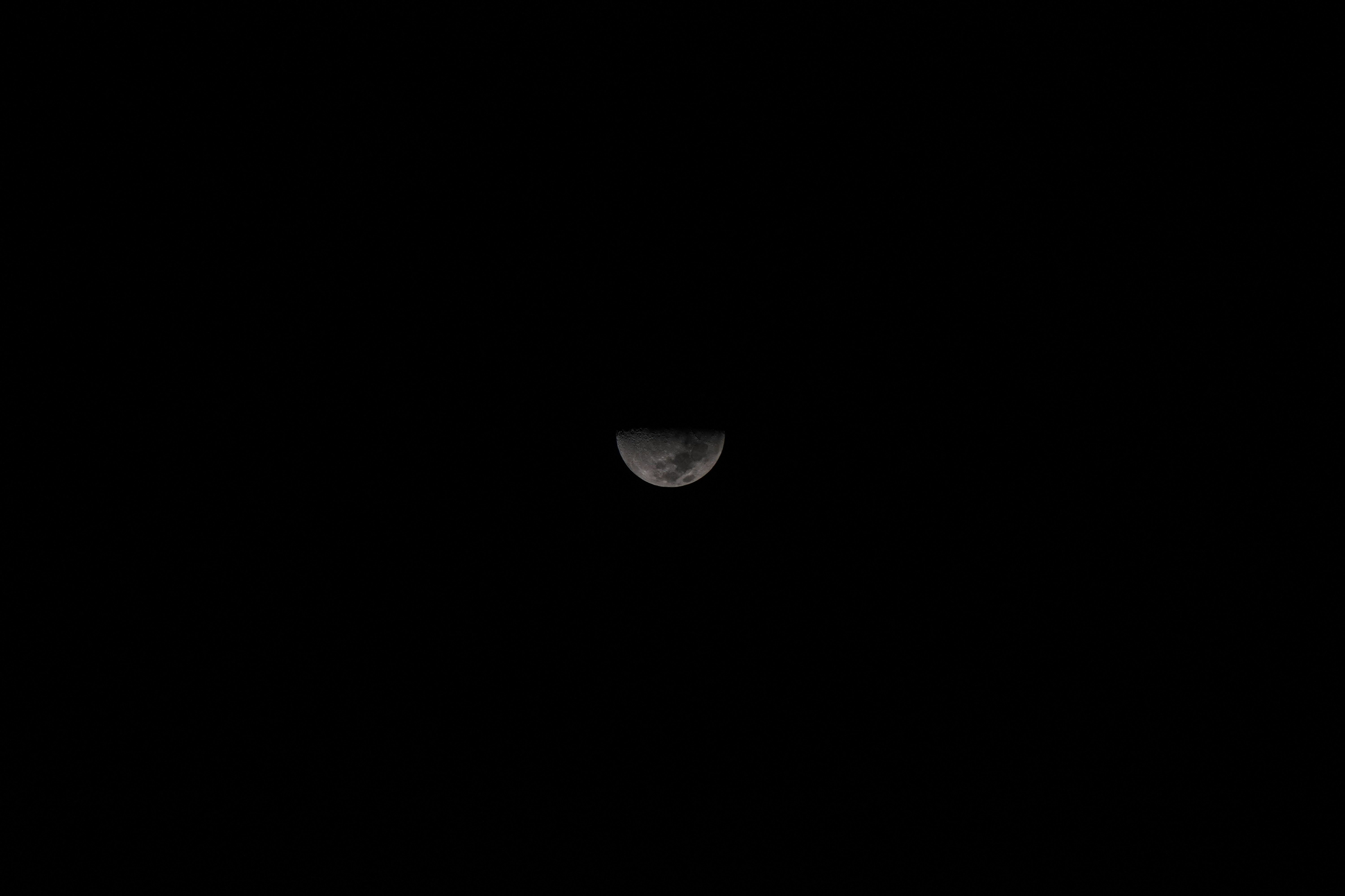 Um fio da lua no céu escuro da noite.