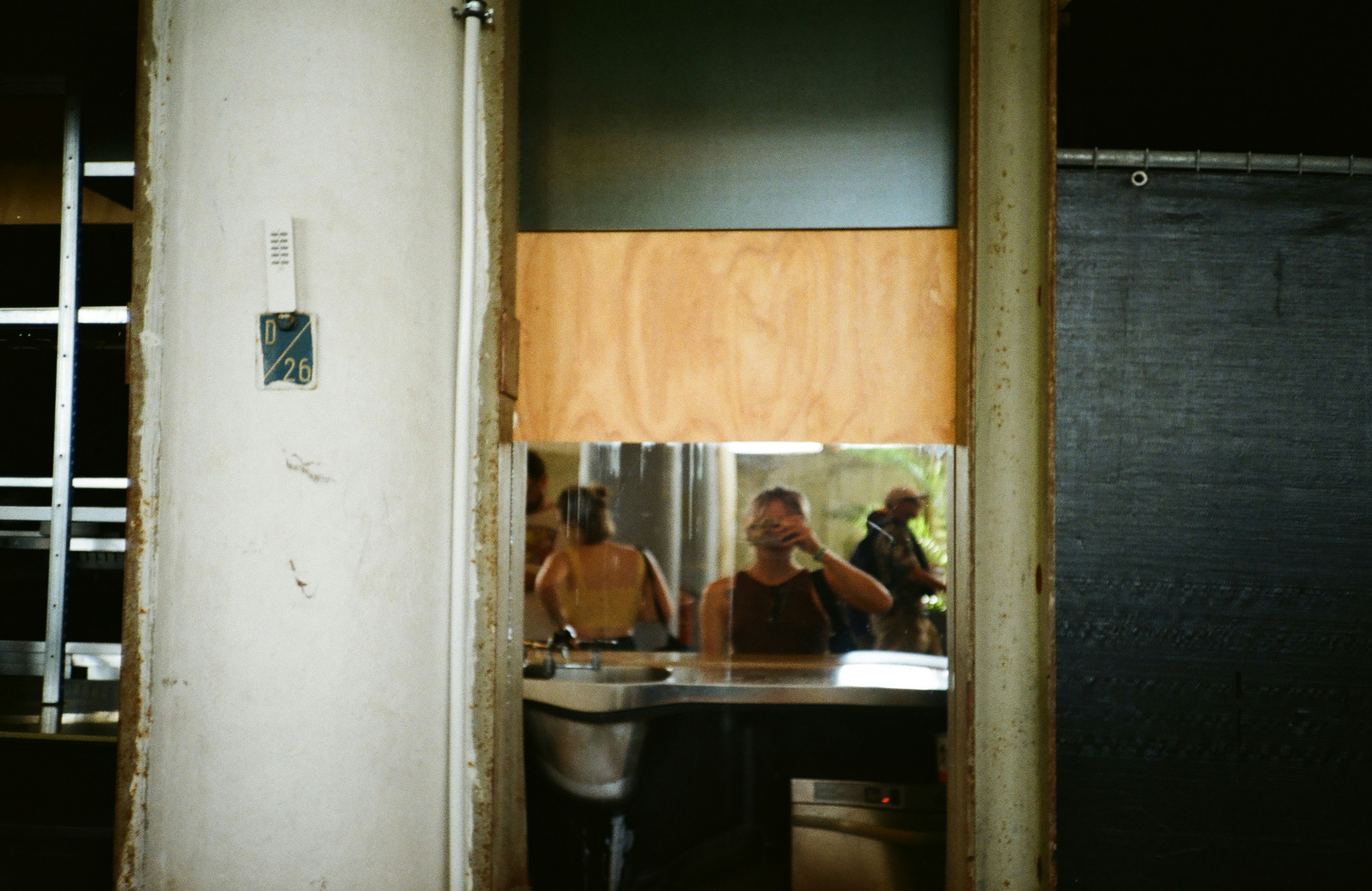 Tre persone viste attraverso una porta in un edificio.