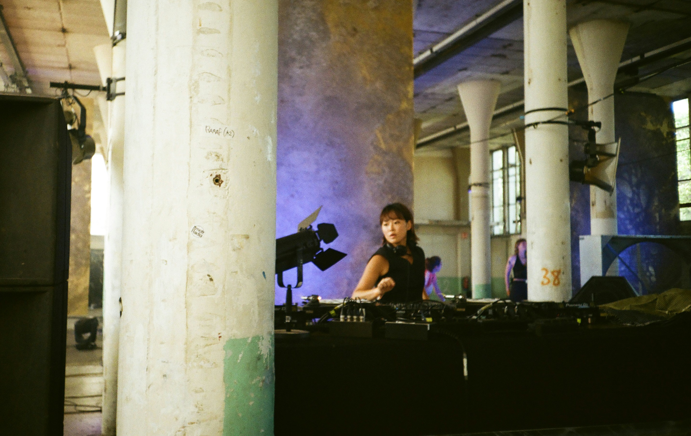 Woman djing in a dimly lit industrial venue