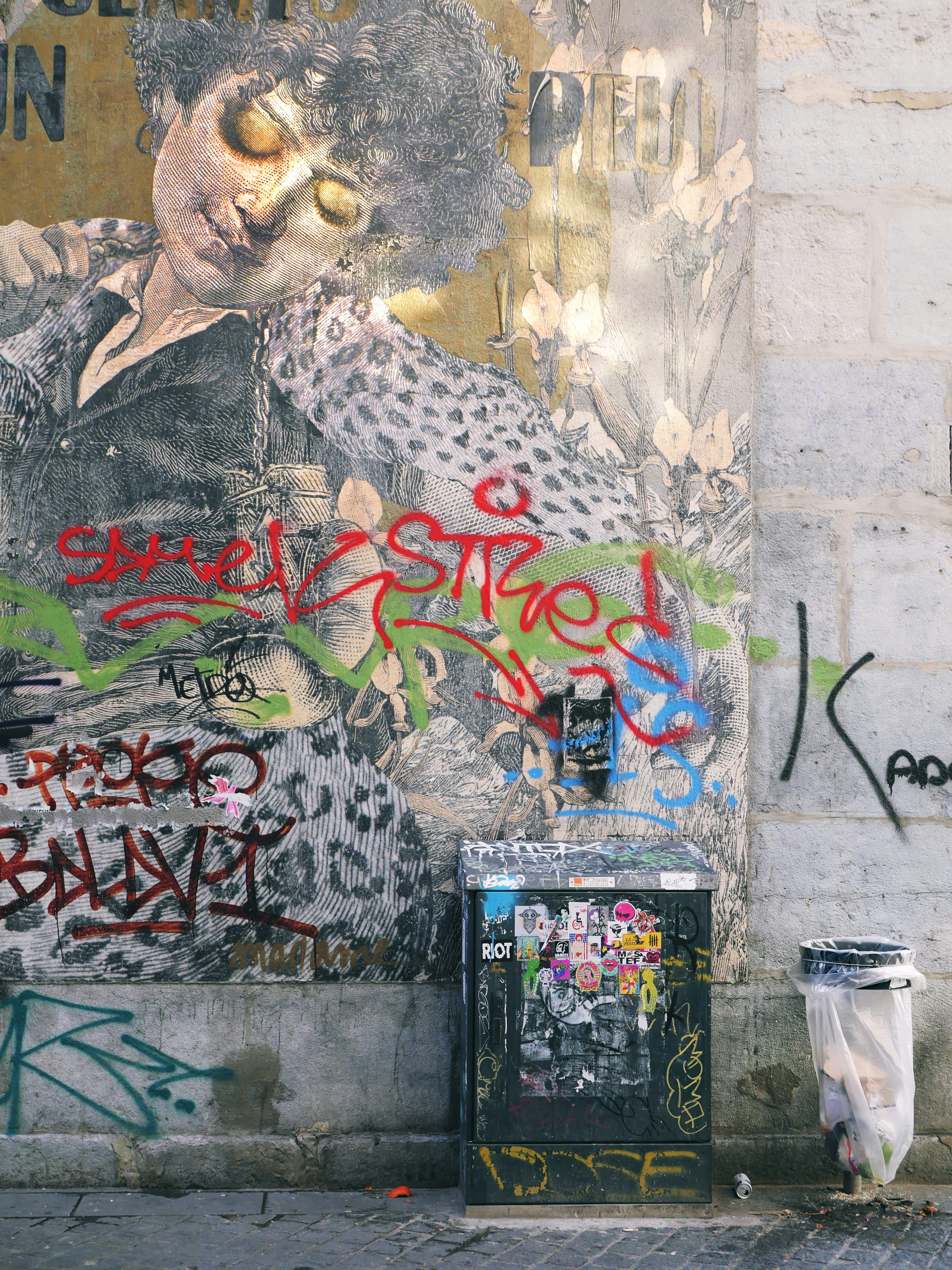 グラフィティアートは風化した壁をゴミ箱で覆っています。