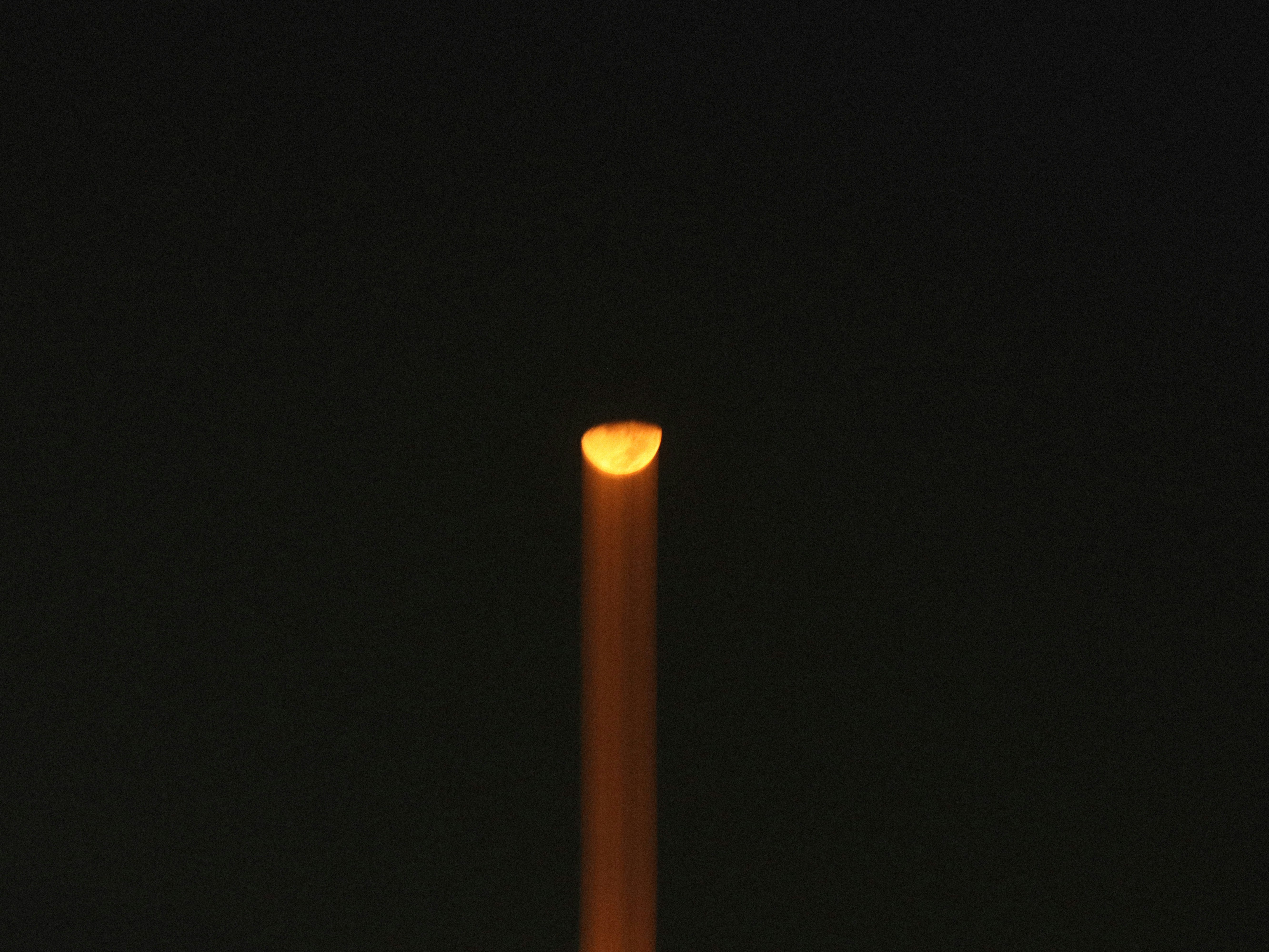 Half moon shining light beam in dark sky