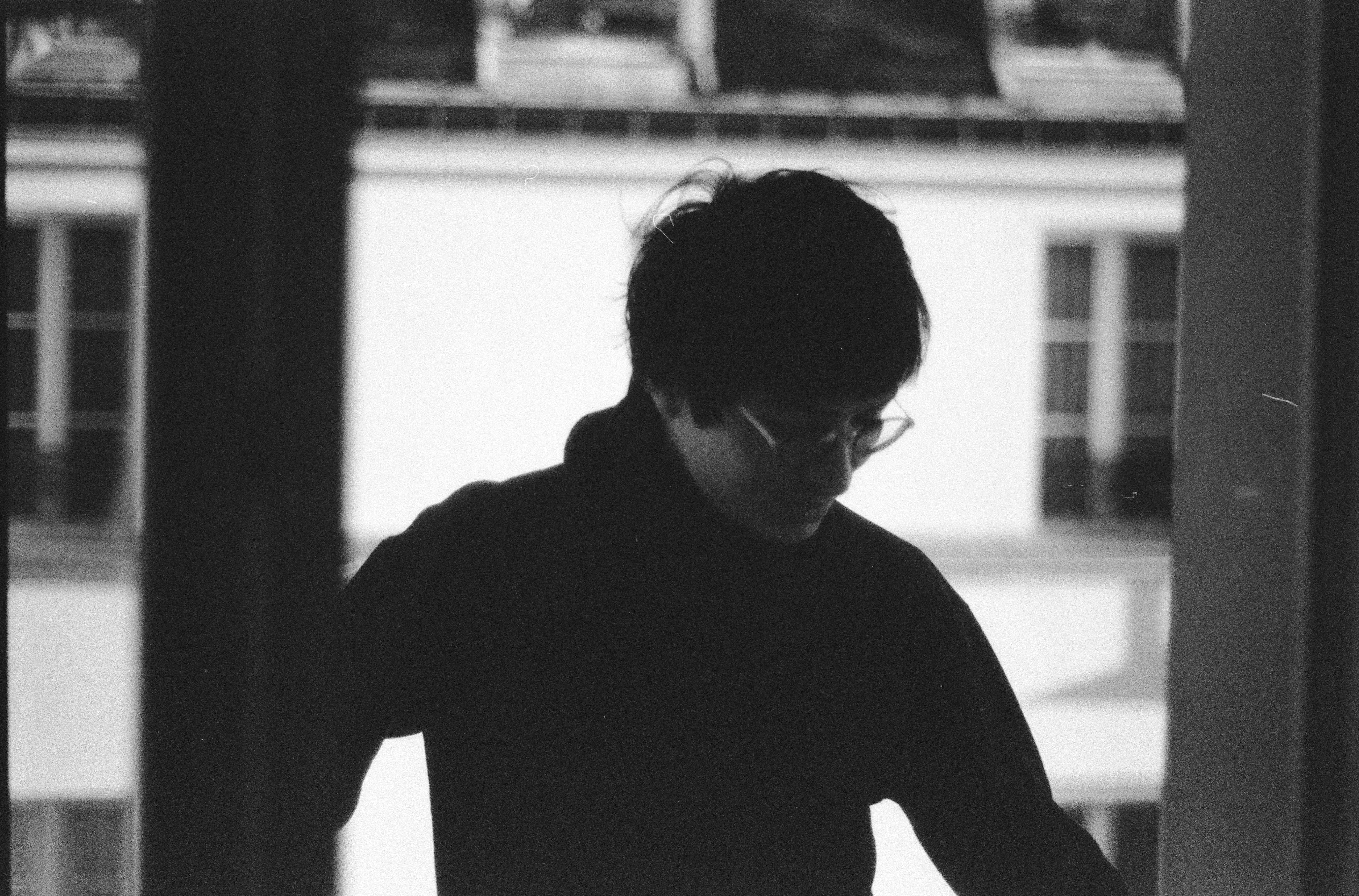 Una persona con gli occhiali guarda dall'alto dentro casa.