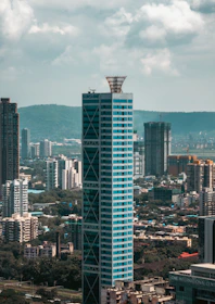 Modern skyscraper with blue glass facade in cityscape.