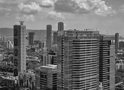 Modern skyscrapers rise against a cloudy sky.