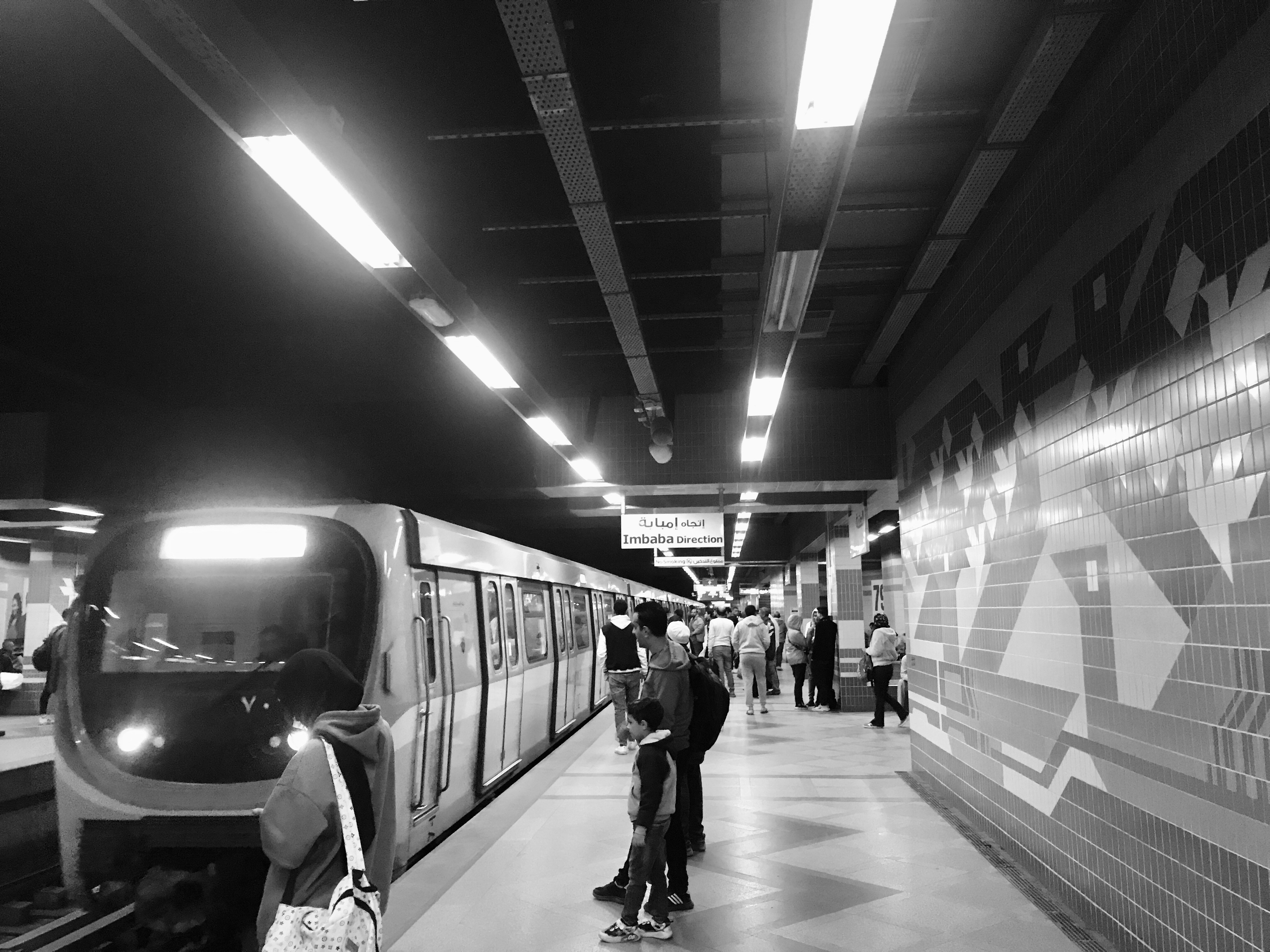 People wait for a train on a subway platform.
