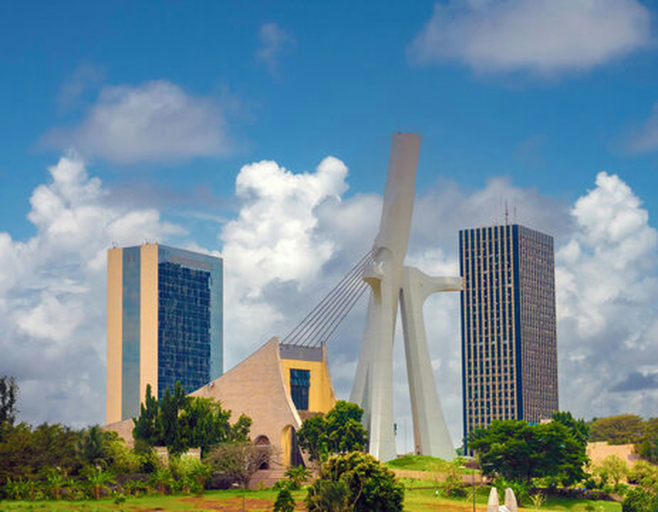 Modern buildings and a unique sculpture under a cloudy sky