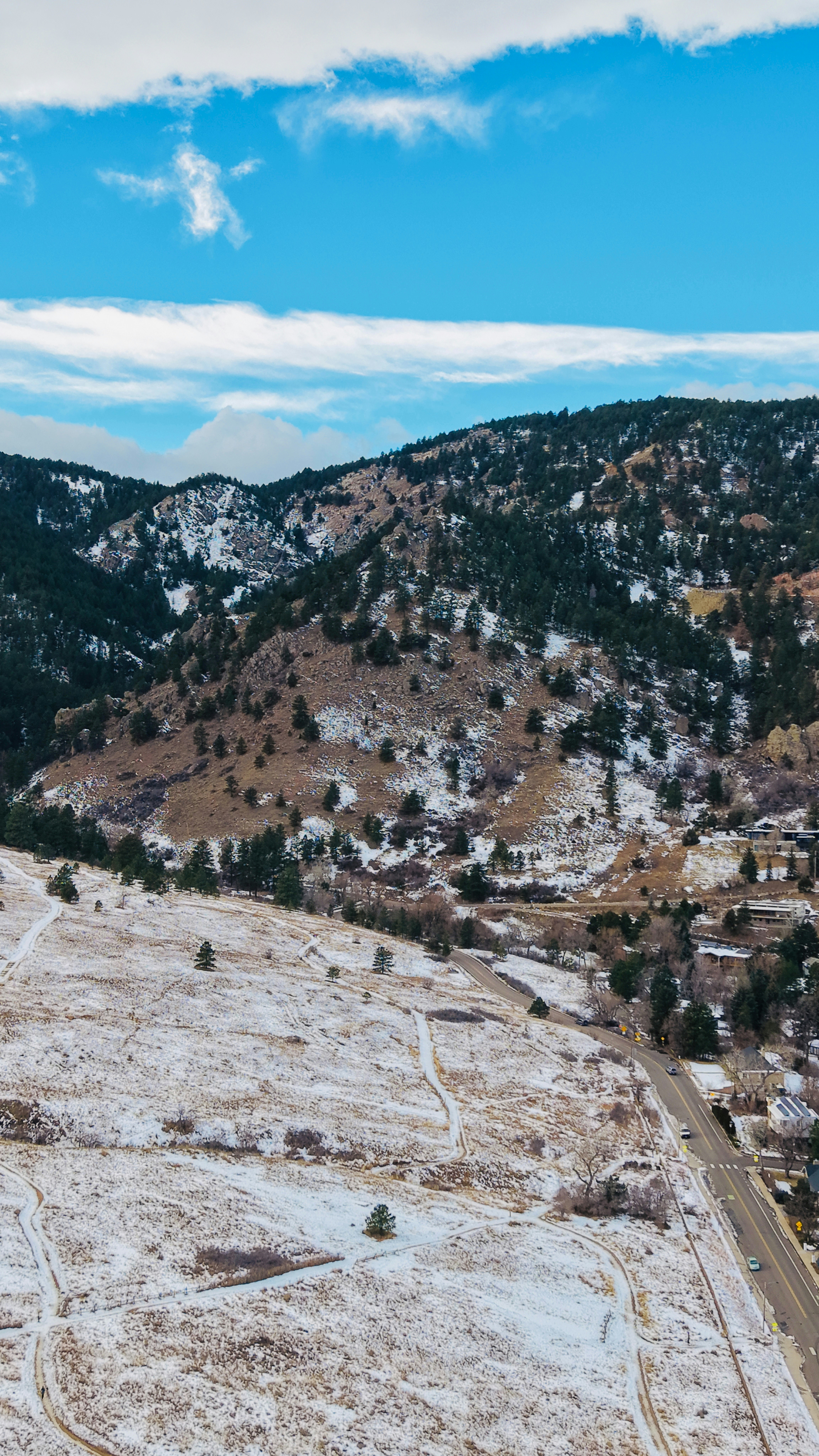 Snowy hills and mountains under a blue sky.
