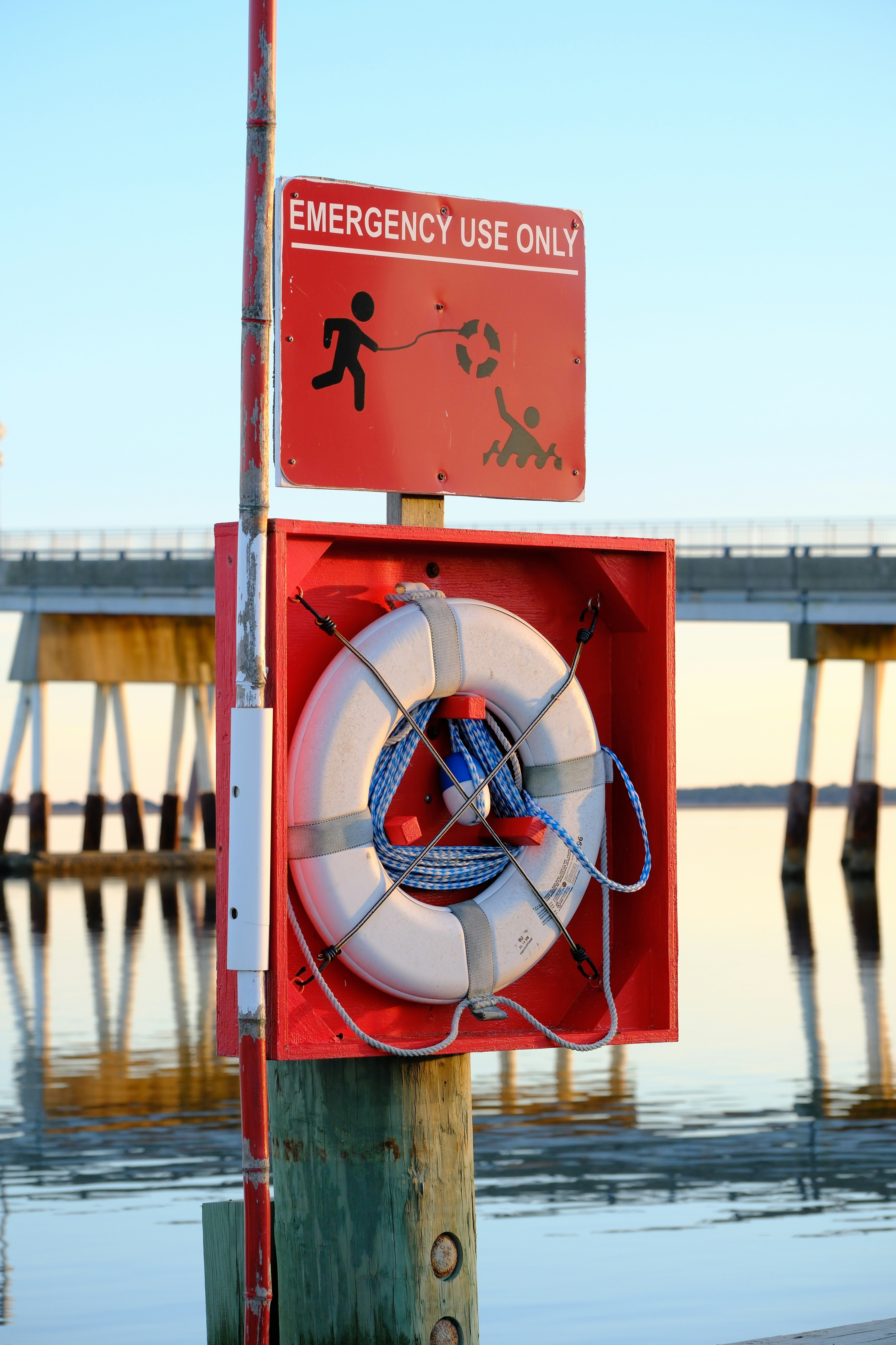 Red life preserver box with emergency use only sign