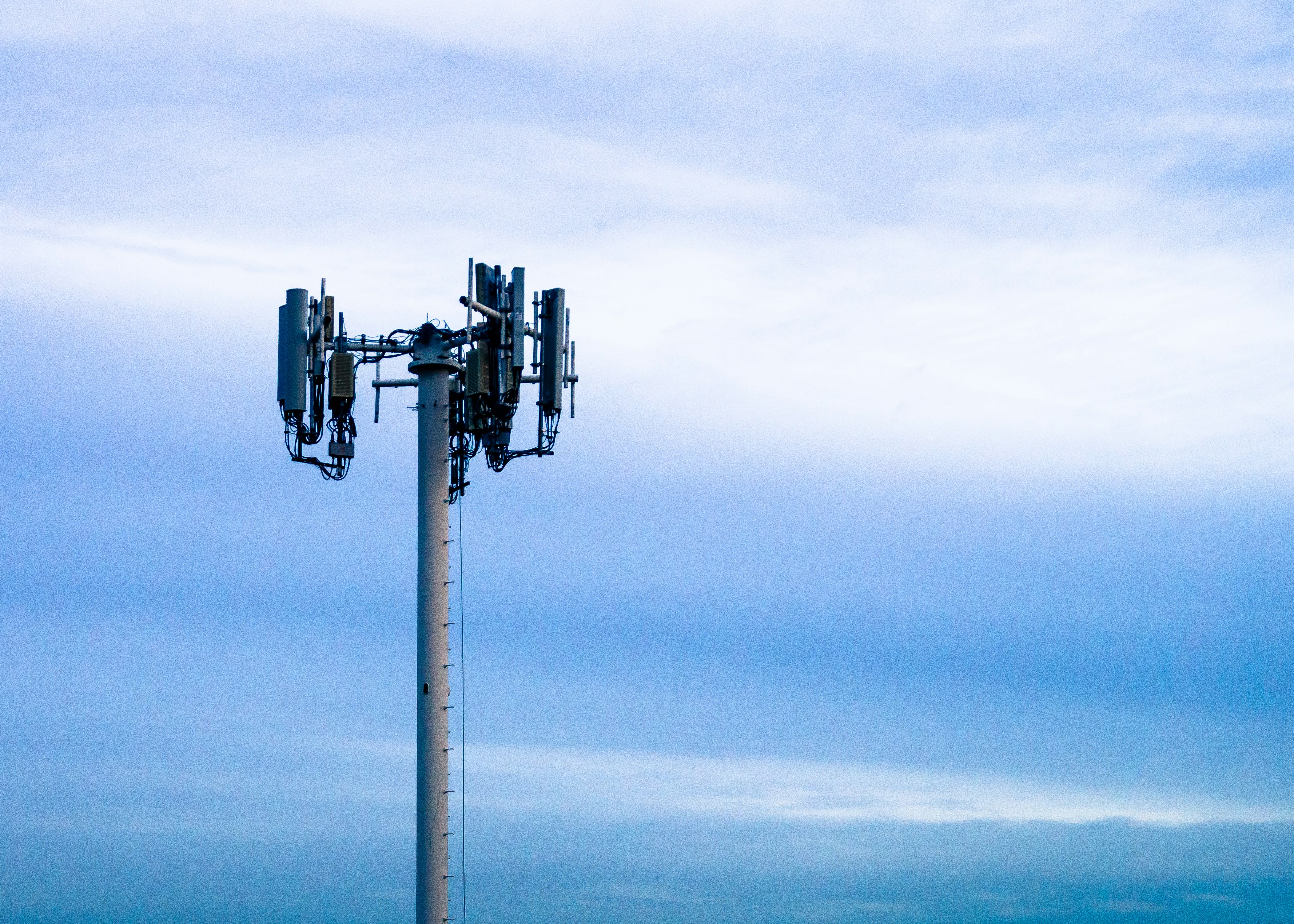 Cell tower against a cloudy blue sky