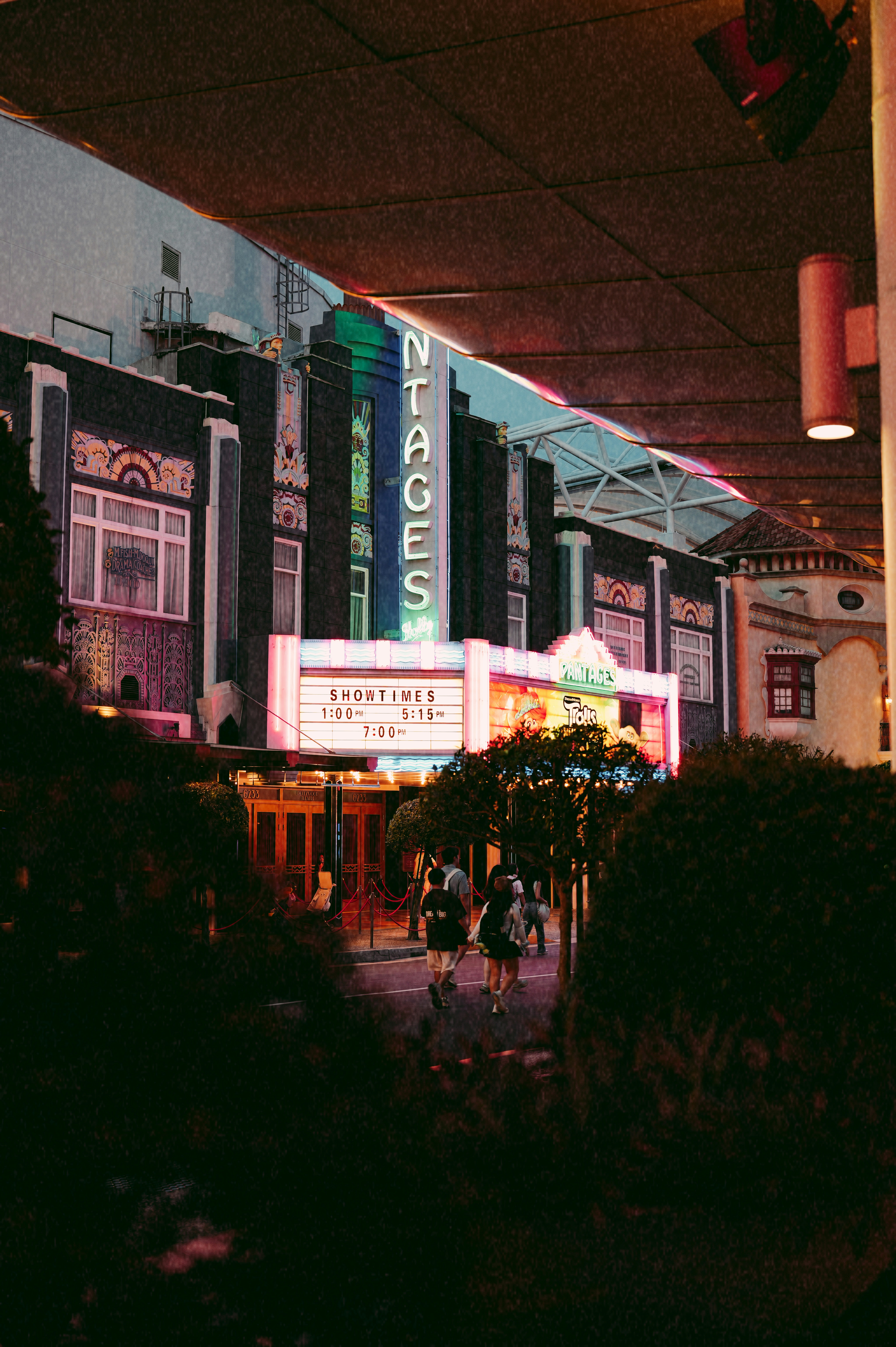 Vintage theater marquee at night with people walking.