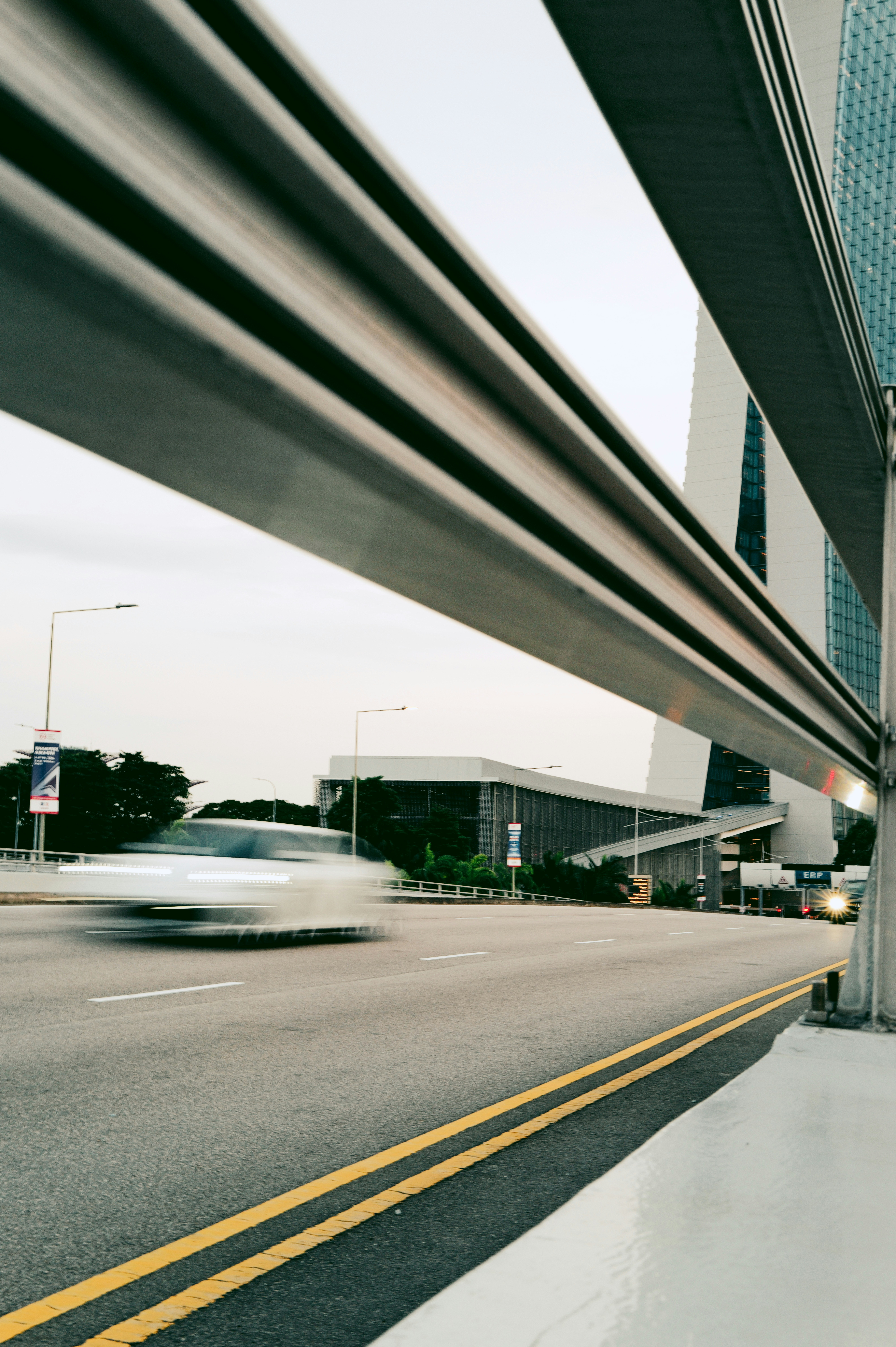 Car blurred in motion on a road with buildings