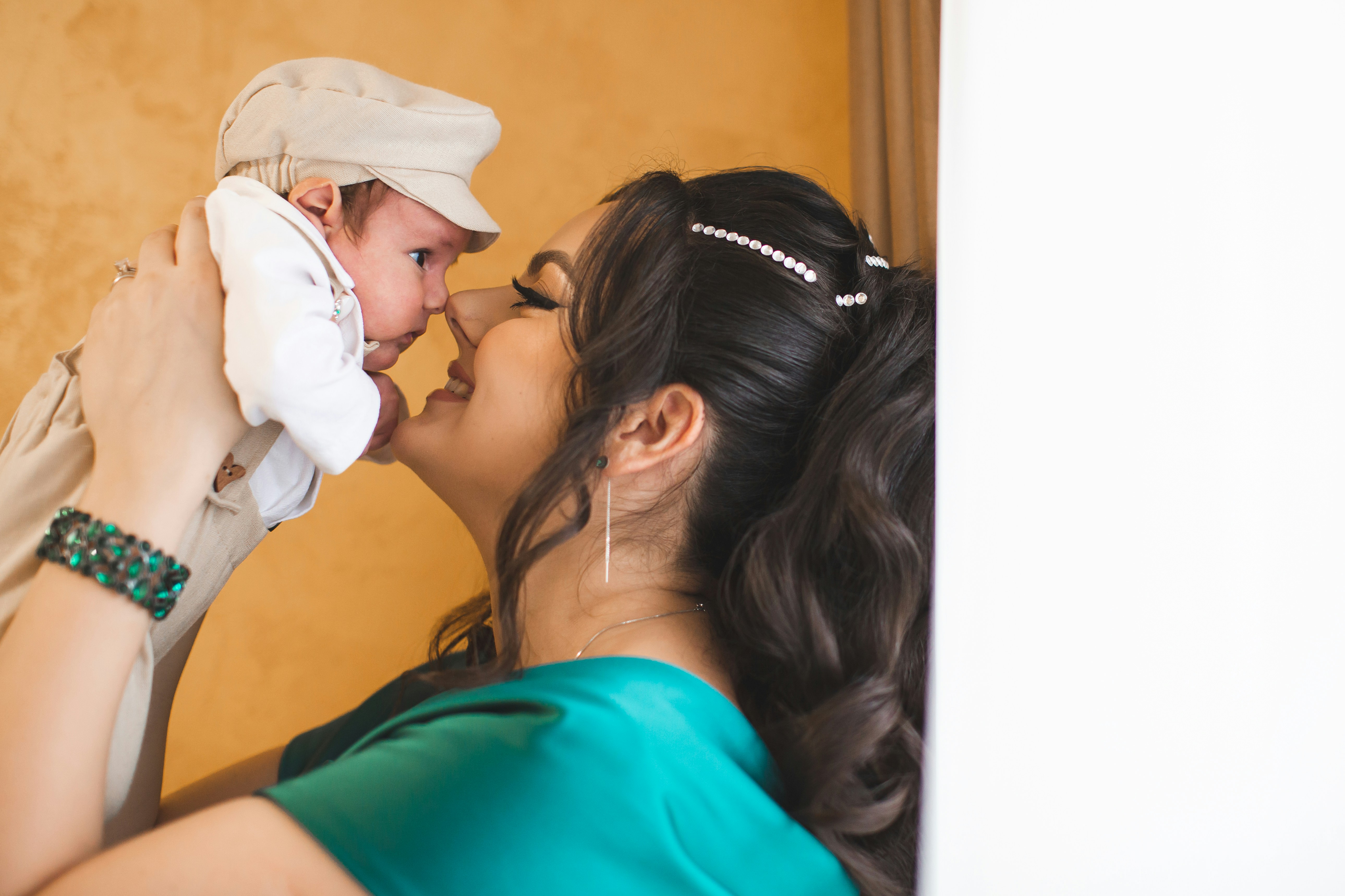 Mother holds her newborn baby near her face.