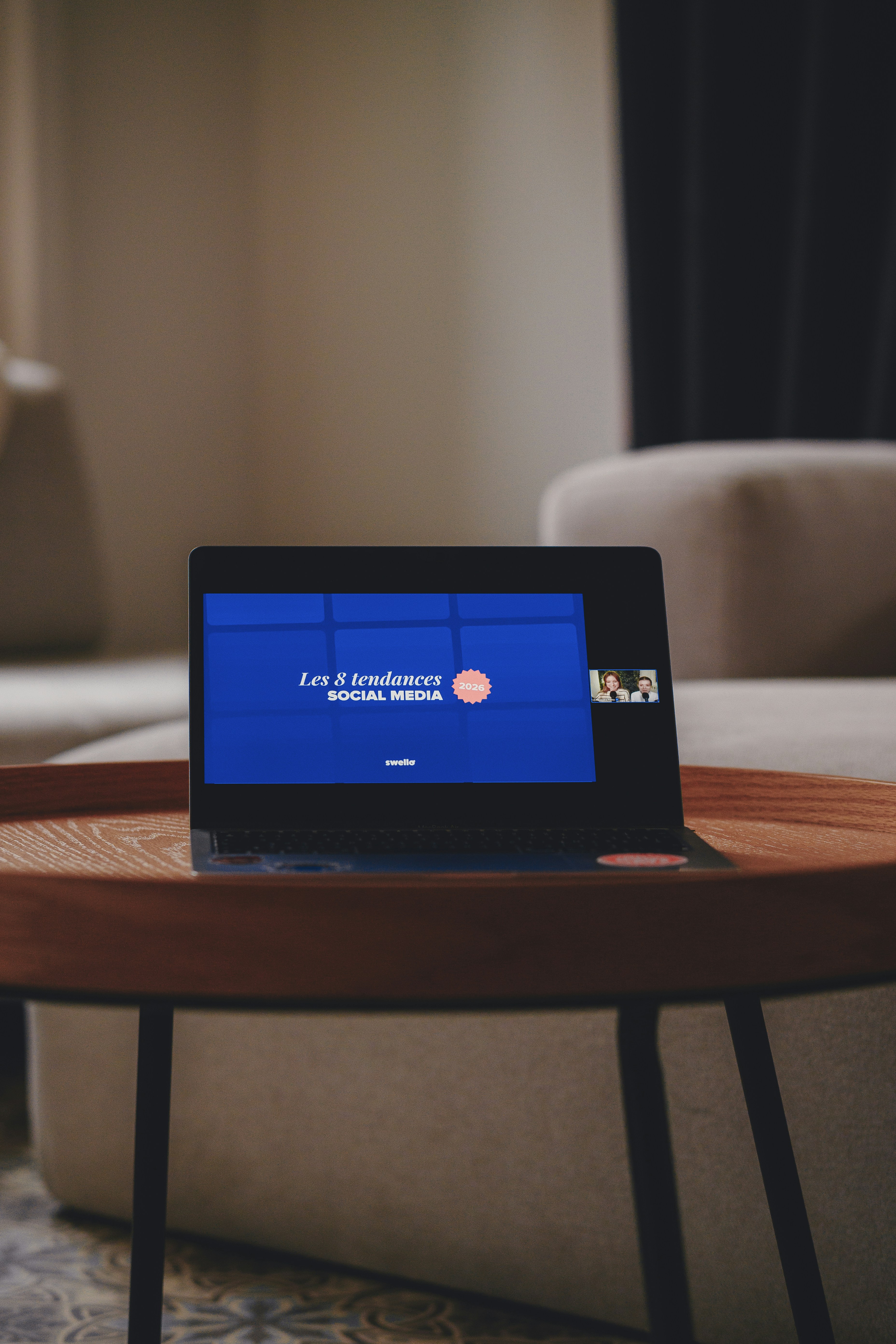 Laptop screen displays social media presentation on a coffee table.