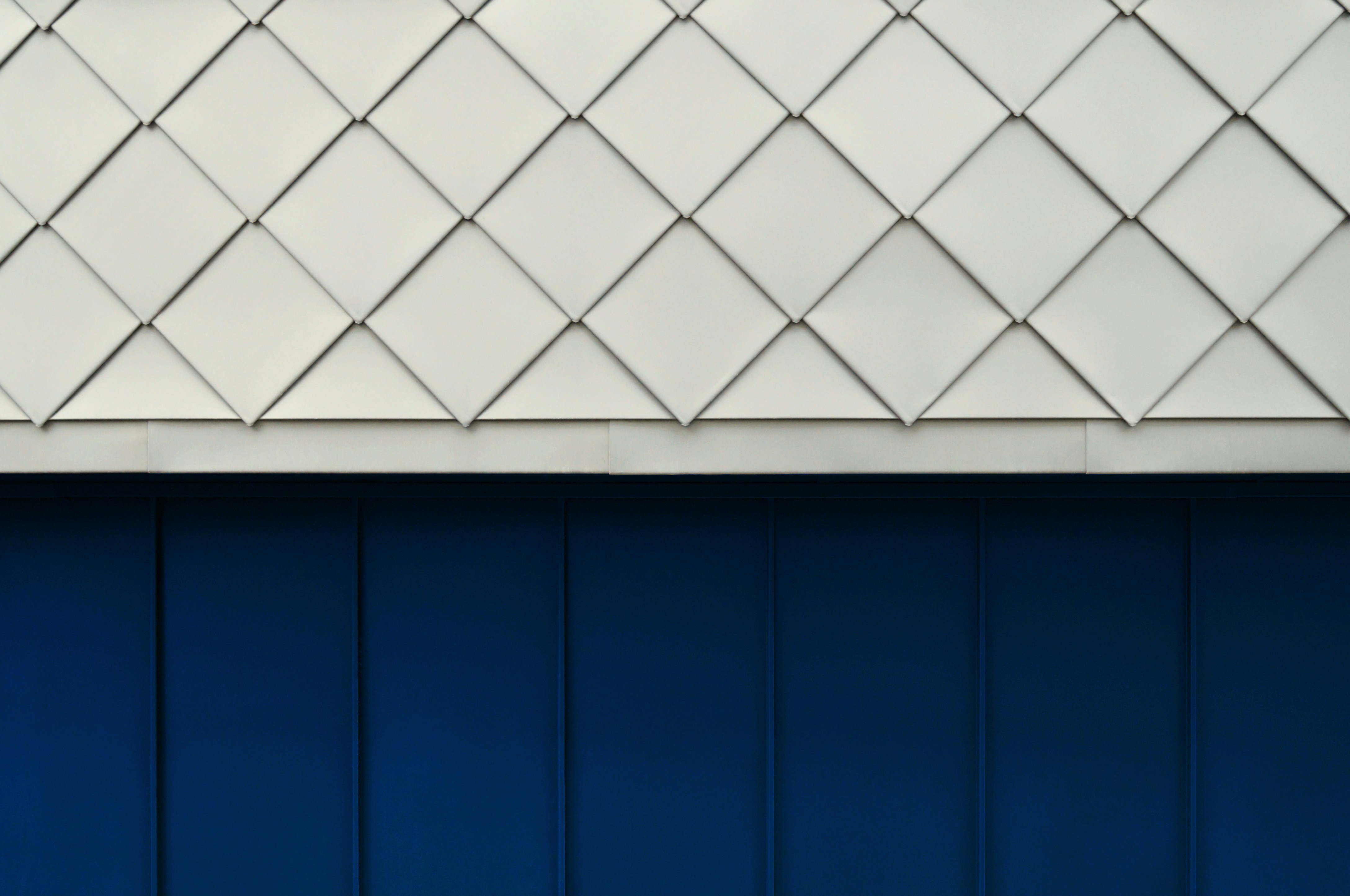 青い壁の上に白いダイヤモンドタイルの幾何学模様。