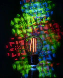 Light bulb with colorful geometric patterns projected behind it