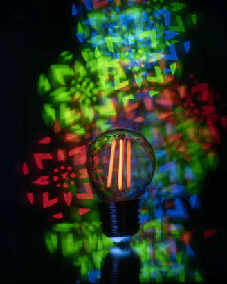 Light bulb with colorful geometric patterns projected behind it